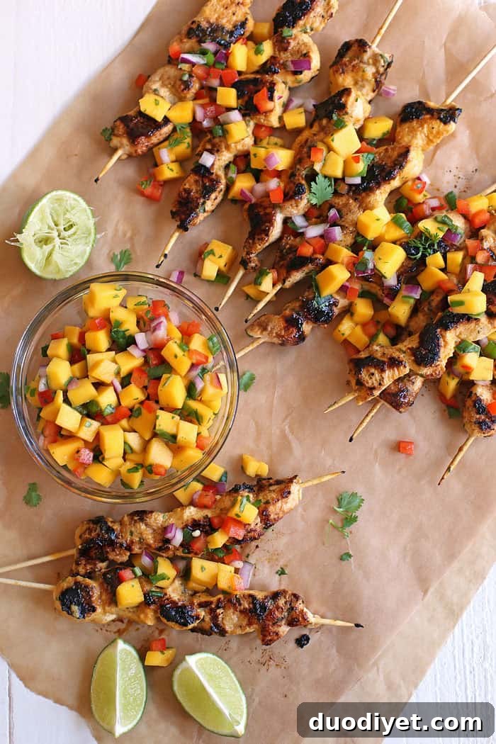 These Mango Sriracha Chicken Skewers are the perfect balance of sweet and spicy topped with a mango salsa that is sure to be a hit at your next cookout! www.eat-yourself-skinny.com