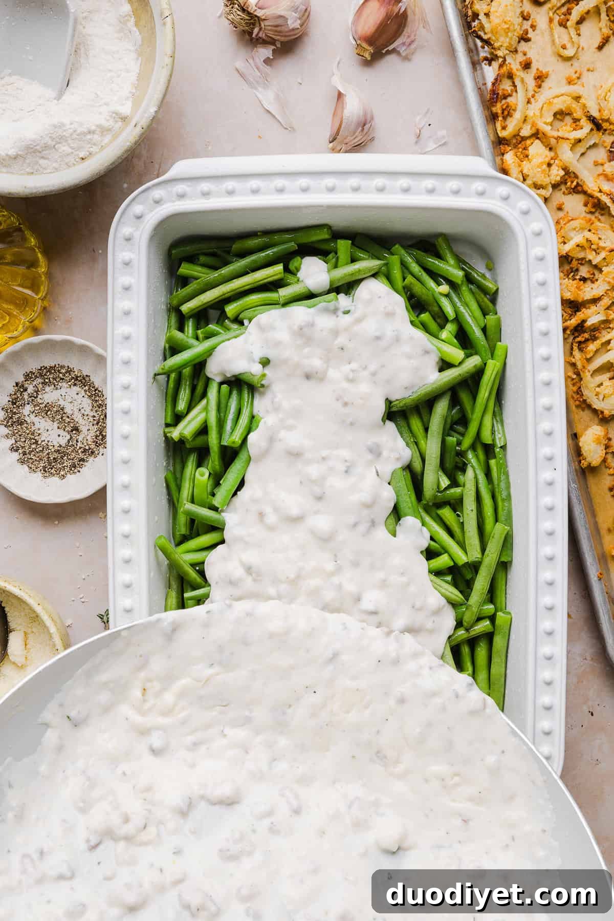 Casserole close-up showing green beans in creamy mushroom sauce topped with crisp onions.