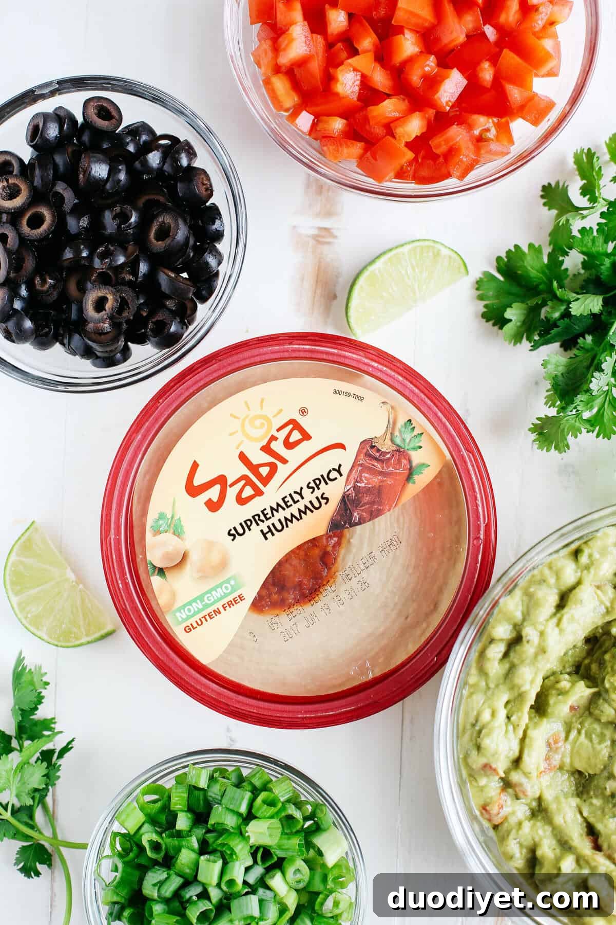Healthy 7 Layer Spicy Taco Dip with layers of hummus, guacamole, salsa and seasoned Greek yogurt