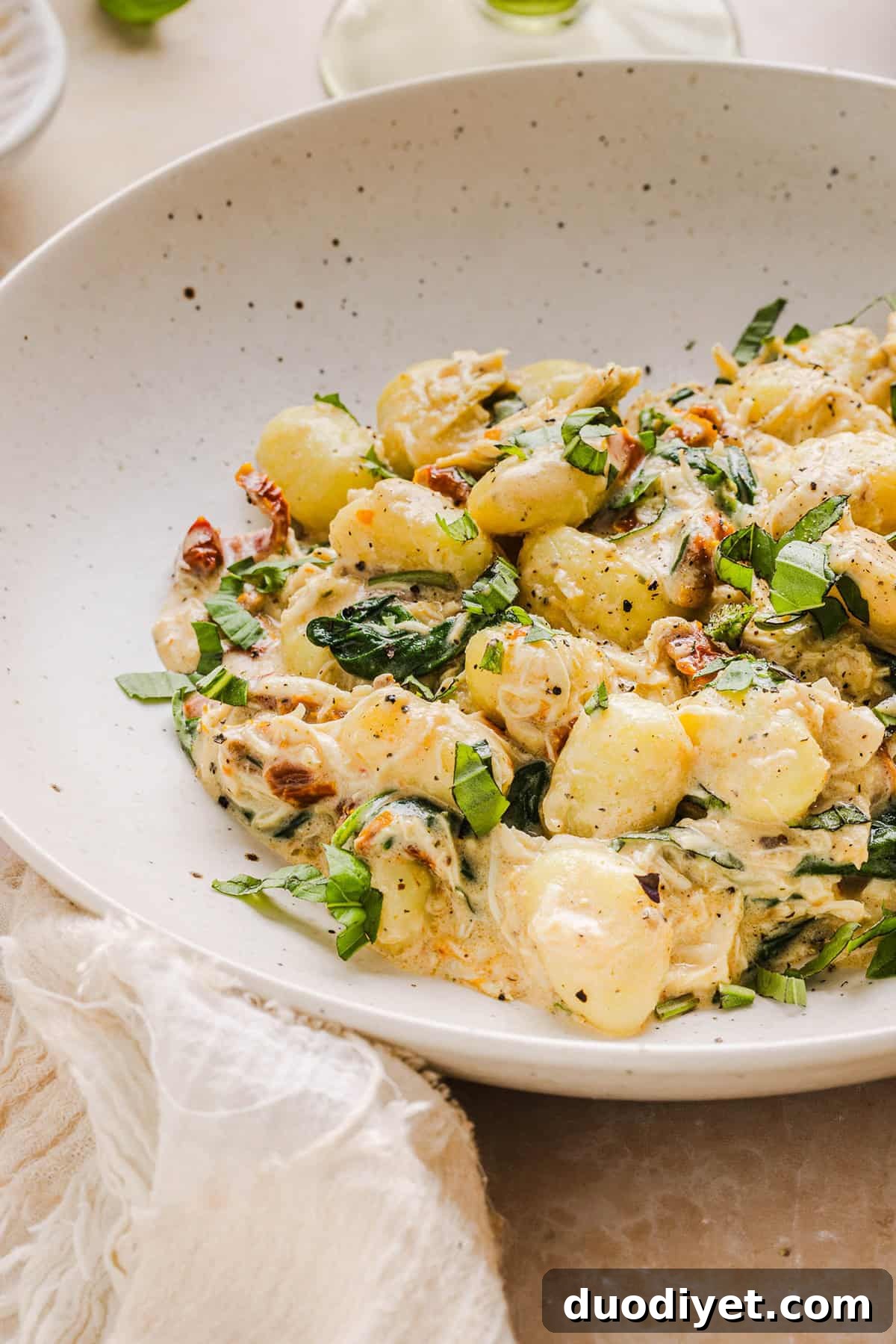 Leftover gnocchi reheated in a skillet, garnished with basil