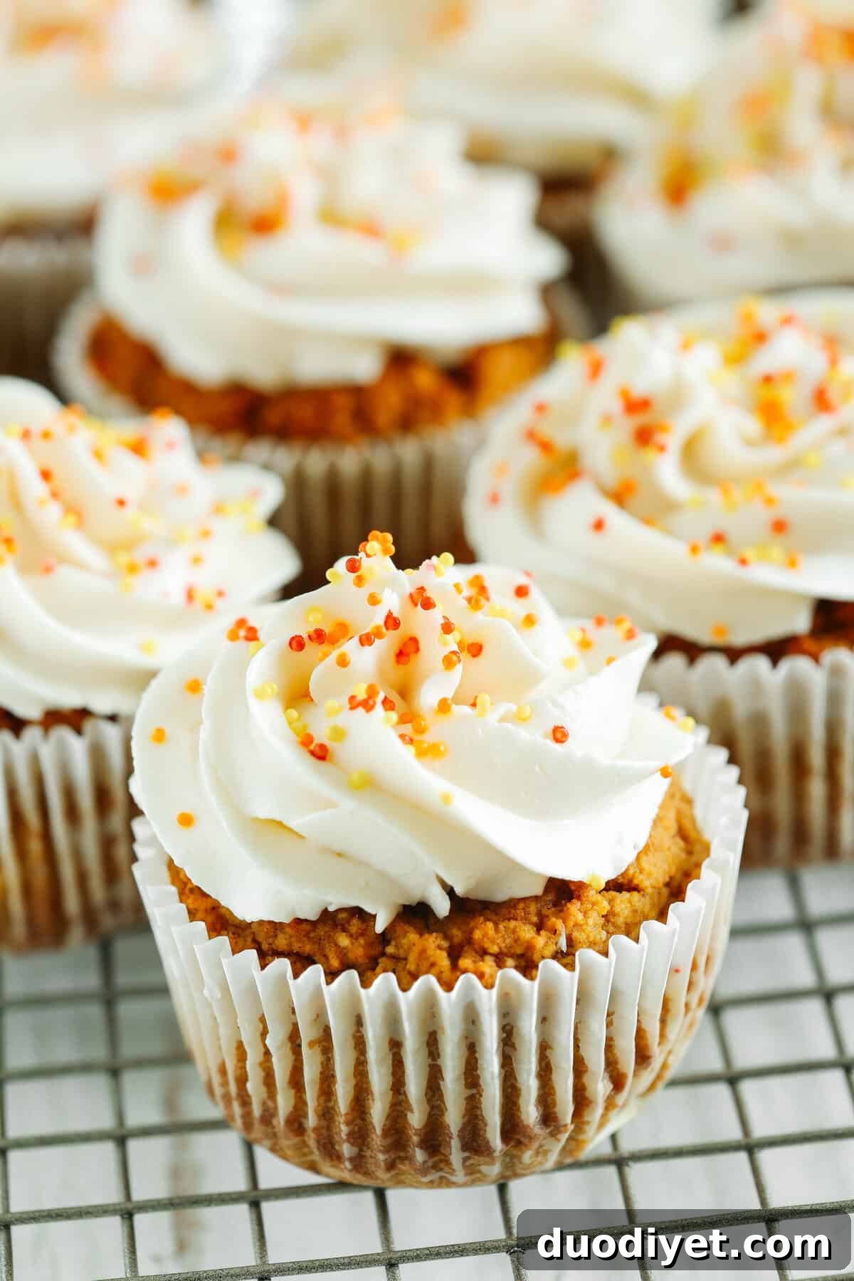 Stack of pumpkin cupcakes with sprinkles