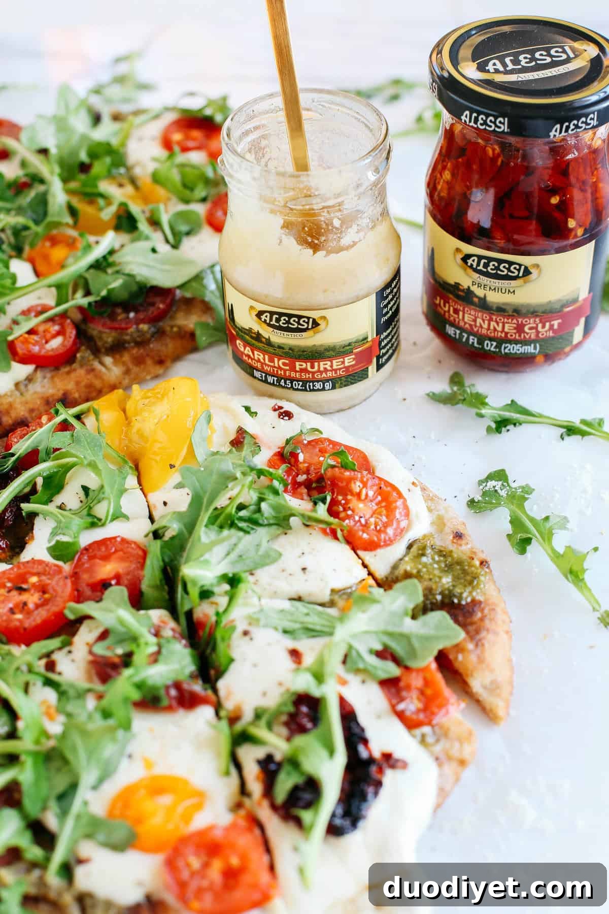 EASY garlicky pesto flatbread pizzas full of fresh tomatoes, basil and arugula for a flavorful weeknight dinner that can be ready in just 15 minutes!