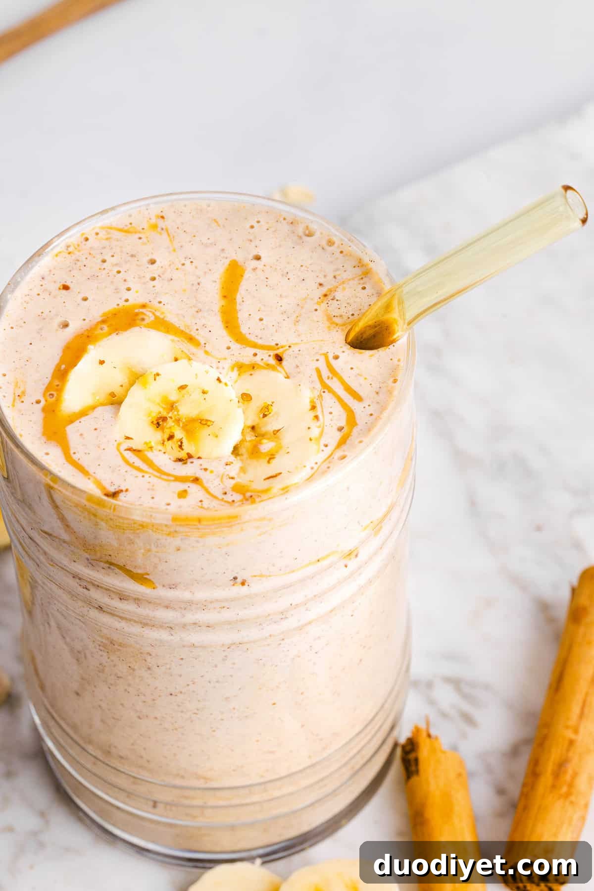 Creamy Banana Oat Breakfast Smoothie 5 Jar of banana oat smoothie with cinnamon and oats on the side.