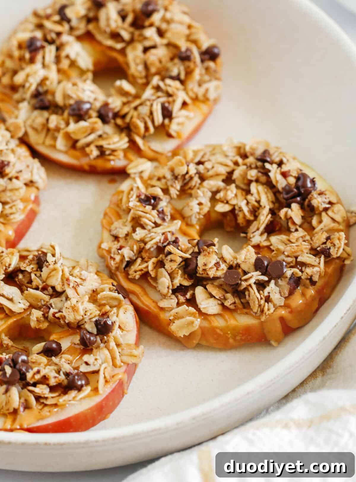 Peanut Butter Granola Apple Rings: sliced apples drizzled with peanut butter and topped with cinnamon pecan granola and chocolate chips