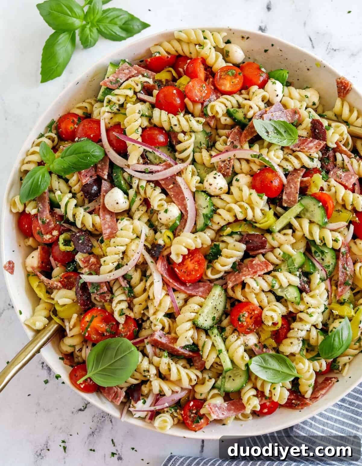 This EASY Italian Pasta Salad is loaded with juicy tomatoes, cucumbers, fresh mozzarella, spicy salami, pepperoncini, red onion and olives all tossed together with a zesty homemade Italian dressing!