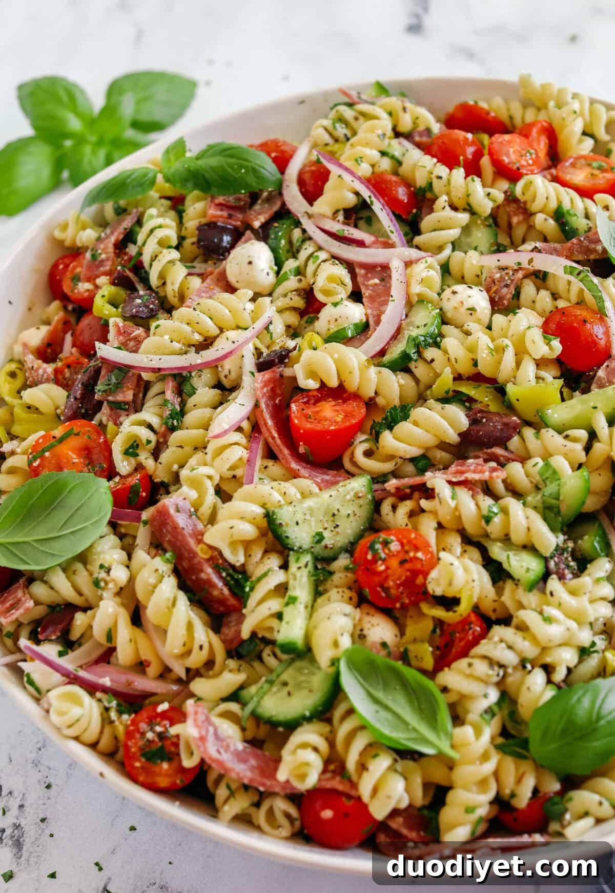 This EASY Italian Pasta Salad is loaded with juicy tomatoes, cucumbers, fresh mozzarella, spicy salami, pepperoncini, red onion and olives all tossed together with a zesty homemade Italian dressing!