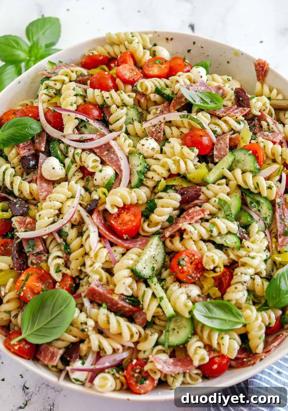 This EASY Italian Pasta Salad is loaded with juicy tomatoes, cucumbers, fresh mozzarella, spicy salami, pepperoncini, red onion and olives all tossed together with a zesty homemade Italian dressing!