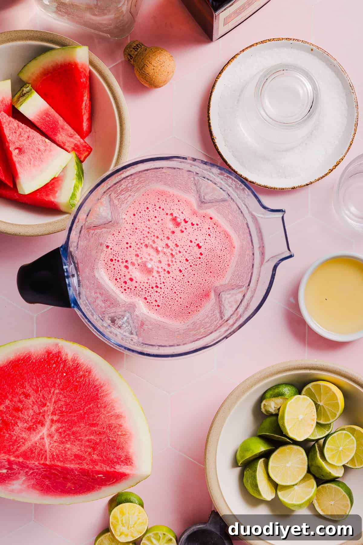 Two watermelon margaritas garnished with lime and watermelon