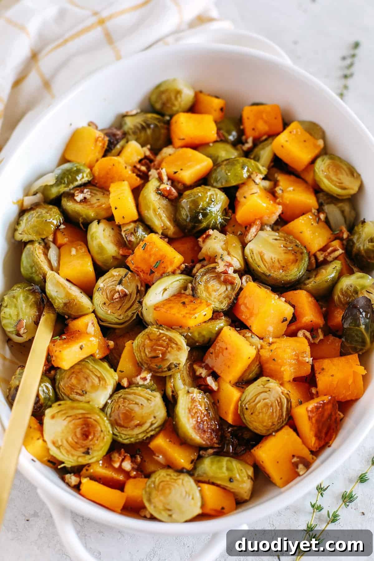Maple-Glazed Butternut Squash and Brussels Sprouts Recipe 2 Roasted butternut squash, brussels sprouts and apples all tossed together with fresh herbs, chopped pecans and drizzled with a delicious maple dijon glaze! The perfect side dish to your holiday meal!