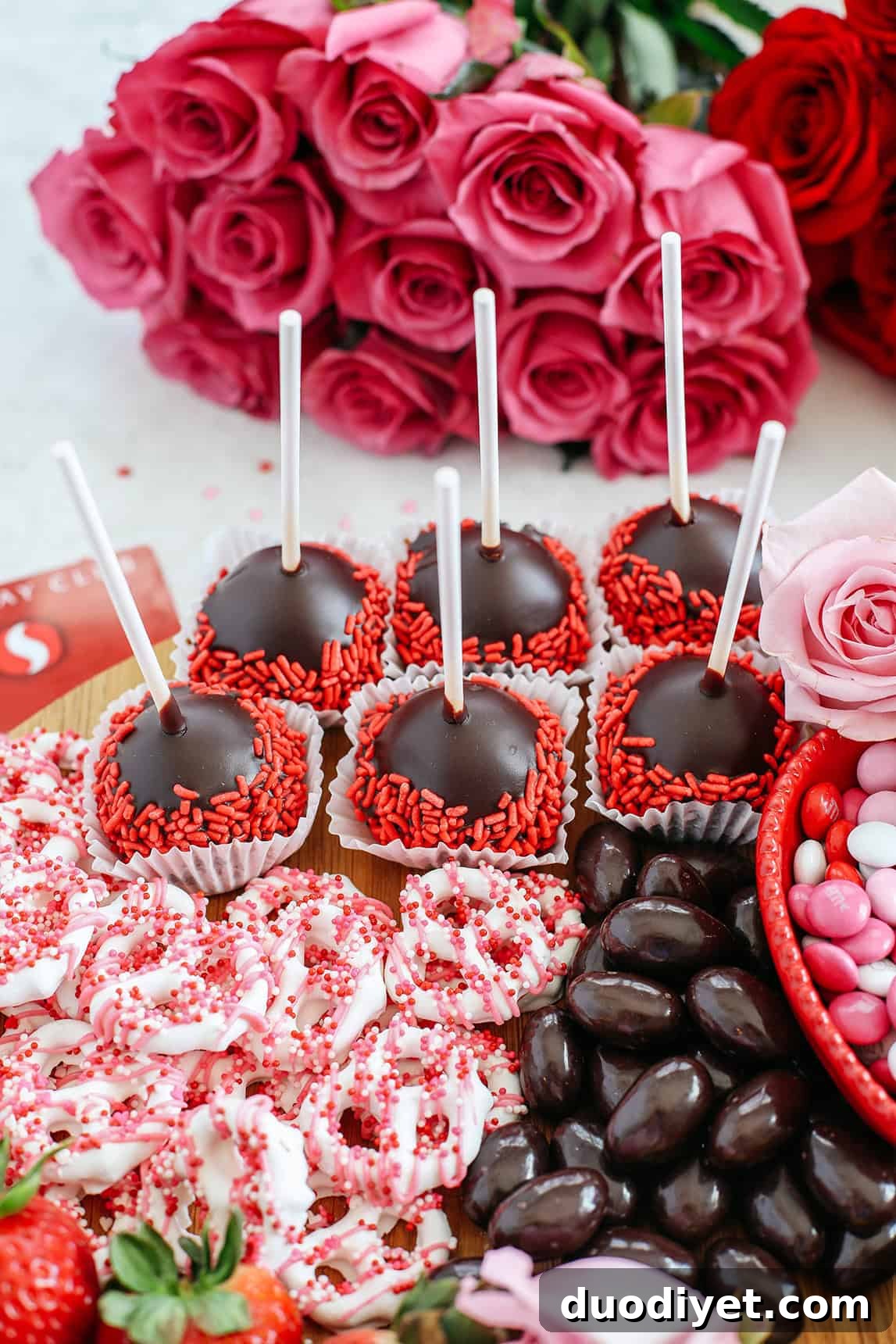 Celebrate Valentine's Day with a fun and festive dessert board made with healthier options like yogurt-dipped pretzels, chocolate covered almonds, fresh fruit and a honey yogurt dipping sauce!