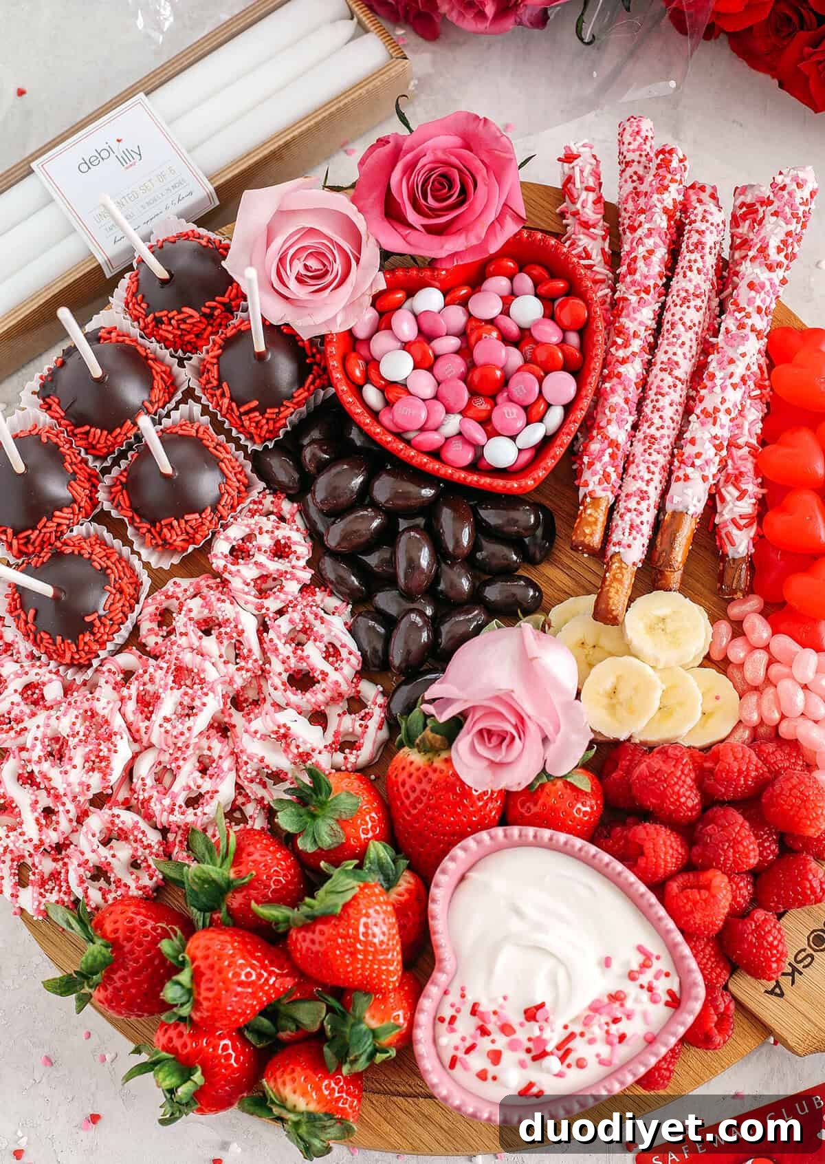 Celebrate Valentine's Day with a fun and festive dessert board made with healthier options like yogurt-dipped pretzels, chocolate covered almonds, fresh fruit and a honey yogurt dipping sauce!