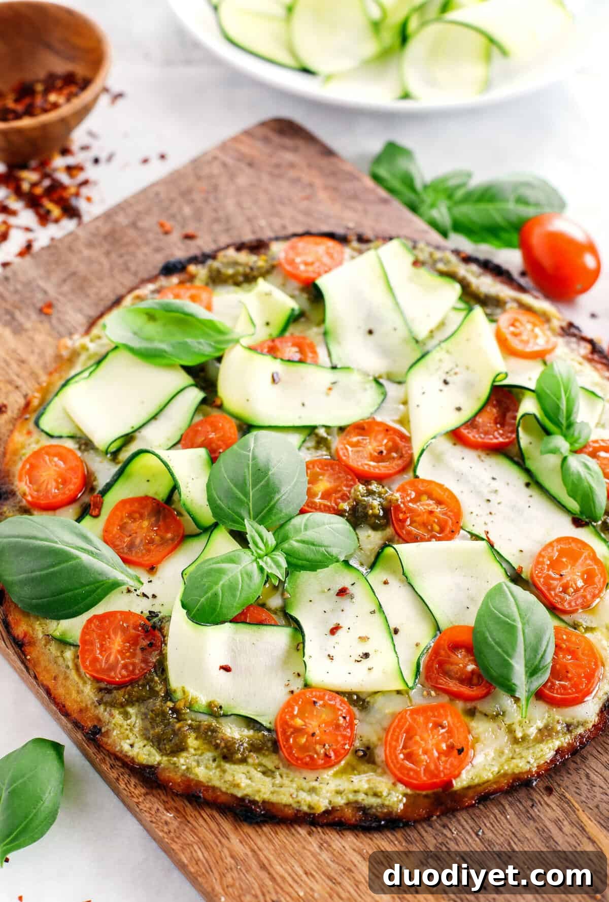 Garden Pesto Cauliflower Pizza loaded with fresh tomatoes, zucchini, homemade basil pesto and ricotta all topped on a crispy cauliflower crust for a delicious low carb meal in just 15 minutes!
