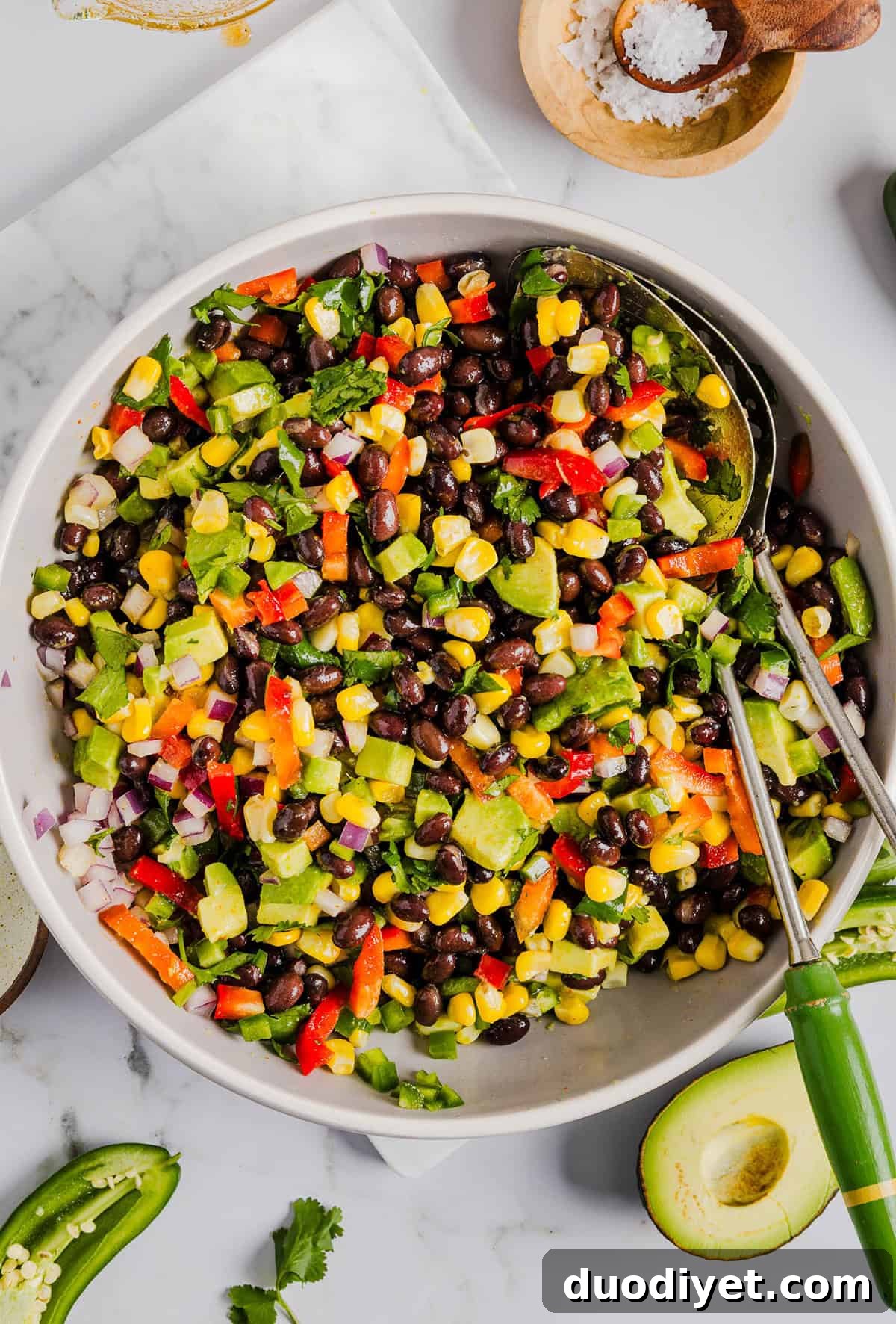 This Black Bean and Corn Salad is loaded with crisp veggies, delicious spices and fresh cilantro, all tossed together in a zesty lime dressing making it the perfect summer side dish or dip!