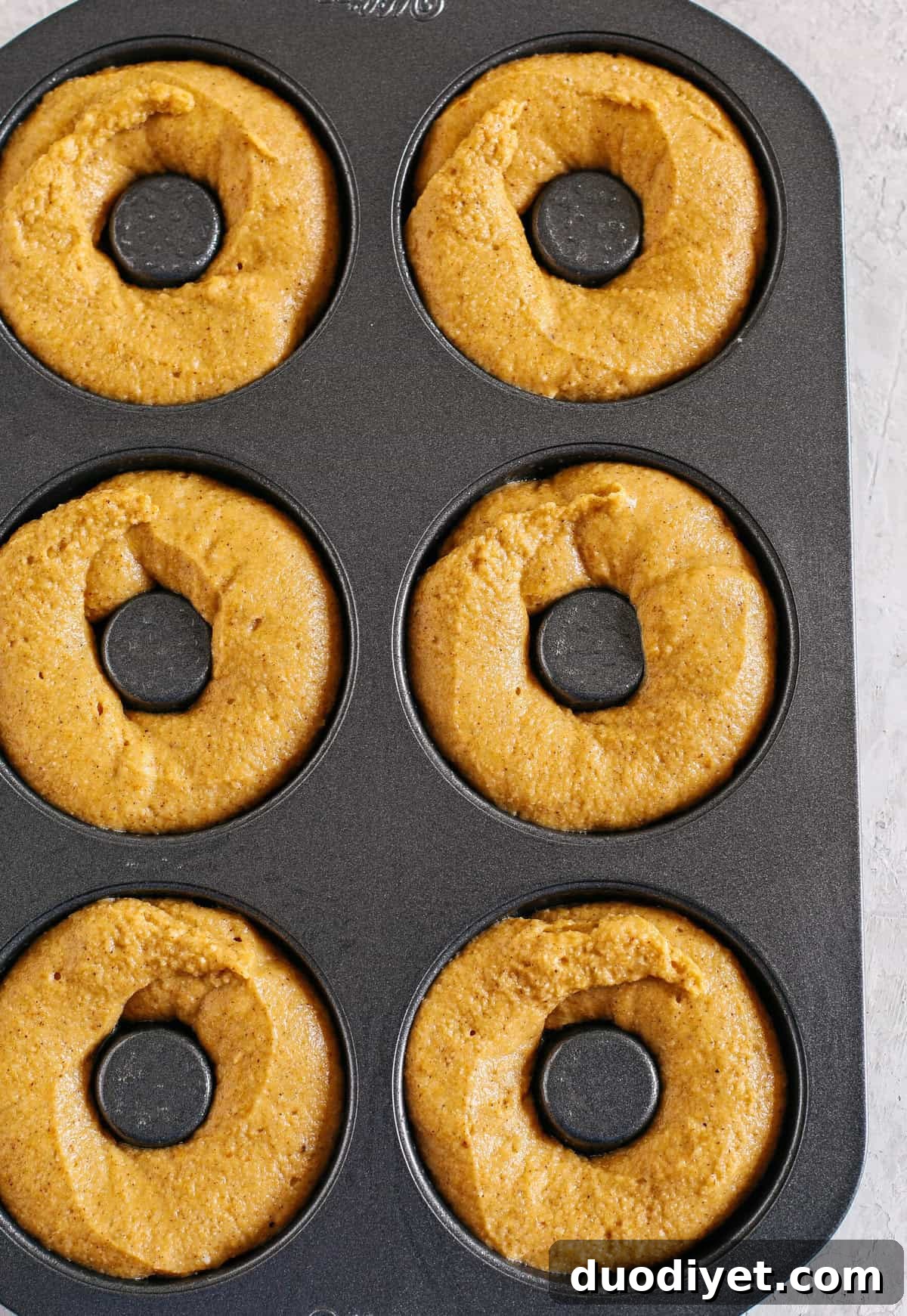 Delicious Gluten-Free Pumpkin Spice Donuts that are soft, lightly sweetened with maple syrup and baked, not fried, for the perfect fall treat! Loaded with warm spices and coated with cinnamon and sugar!