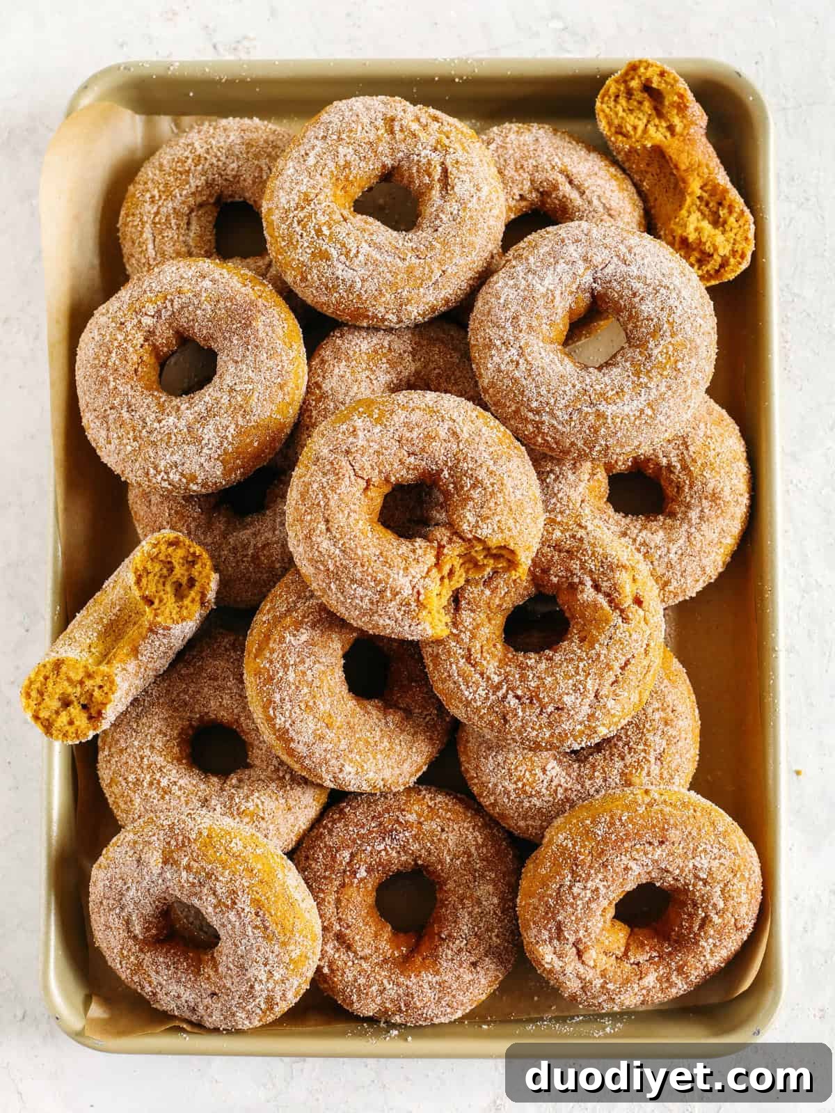 Delicious Gluten-Free Pumpkin Spice Donuts that are soft, lightly sweetened with maple syrup and baked, not fried, for the perfect fall treat! Loaded with warm spices and coated with cinnamon and sugar!