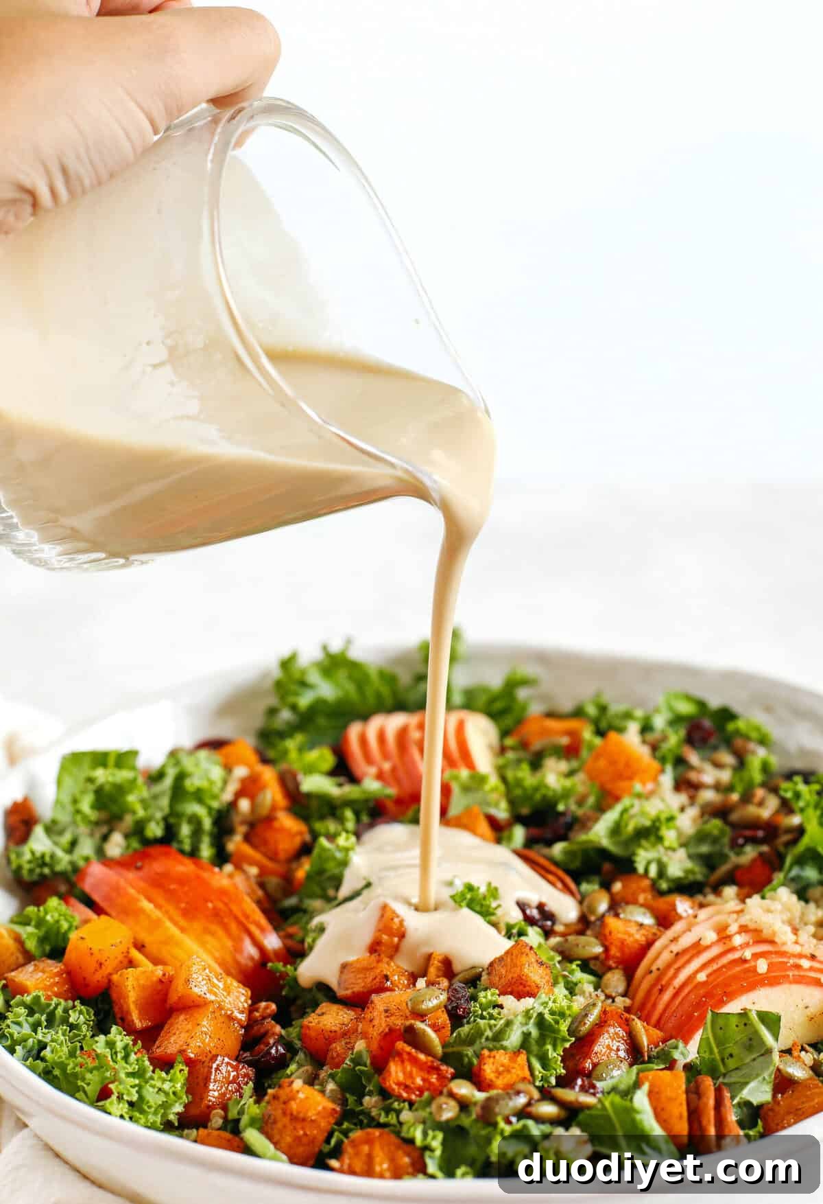 Fall Harvest Salad with Maple Tahini Dressing 3 The ultimate powerhouse Fall Salad made with leafy kale, protein-packed quinoa, sliced apples, roasted butternut squash, and spiced pepitas and pecans, all drizzled in the most delicious maple tahini dressing!