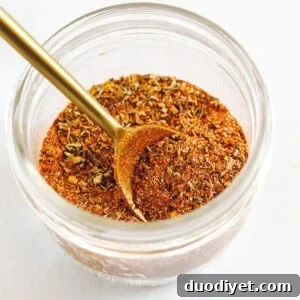 Cajun seasoning in a small jar with spoon