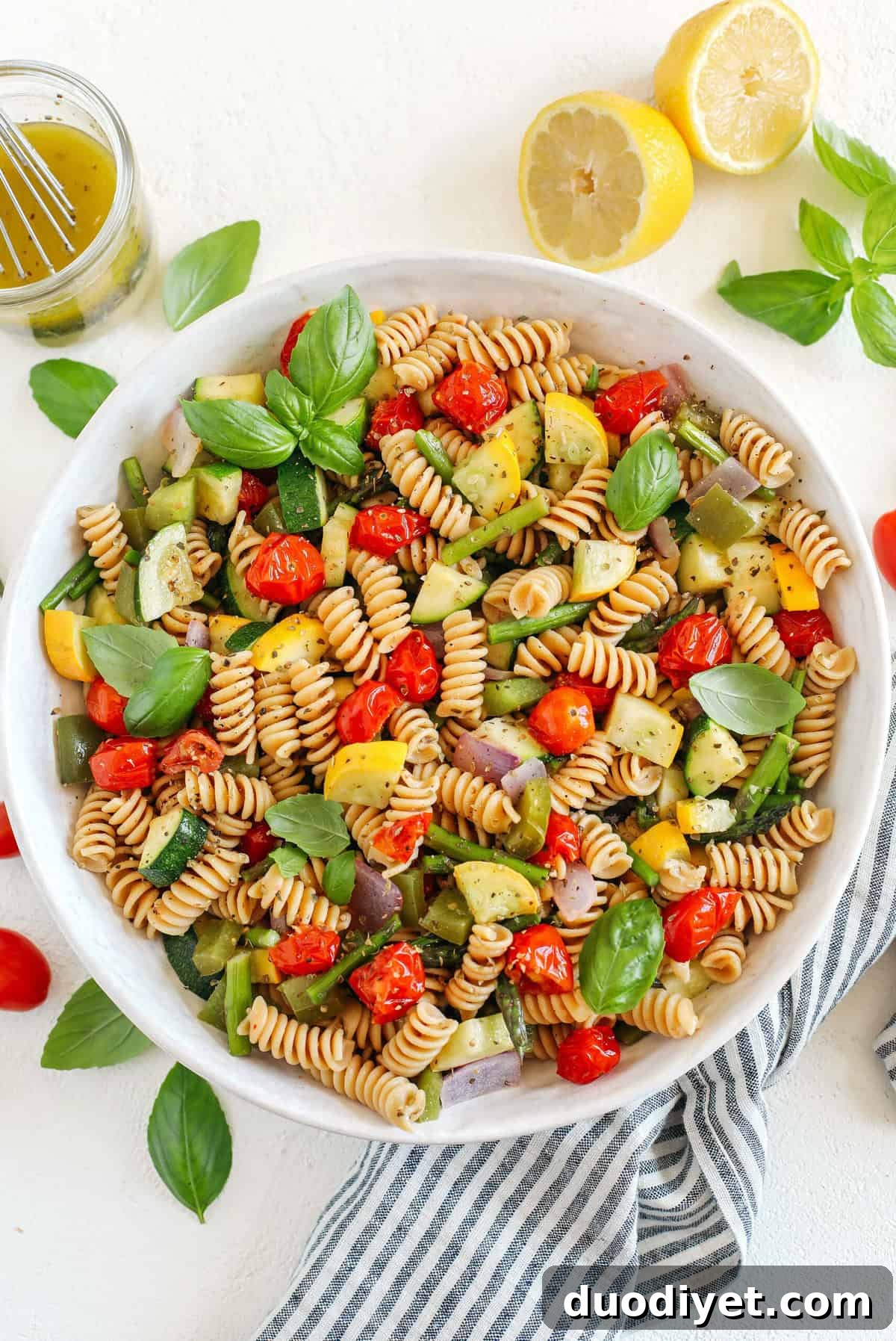 Roasted veggies and pasta being tossed together