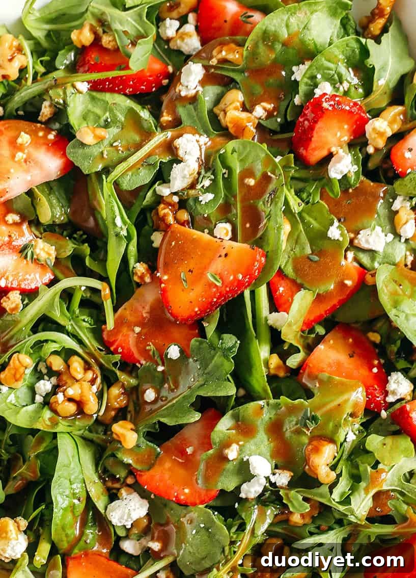 Strawberry salad with greens, walnuts, and goat cheese dressed in maple balsamic vinaigrette