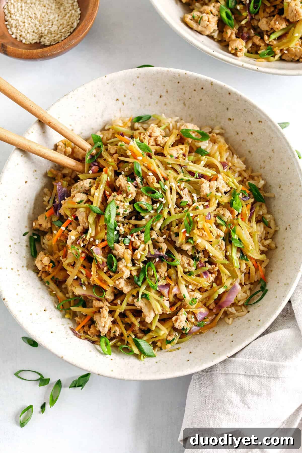 Easy and flavorful Chicken Egg Roll in a Bowl that comes together in under 20 minutes packed with so much flavor! Perfect healthy weeknight dinner served over rice and garnished with green onions and sesame seeds.