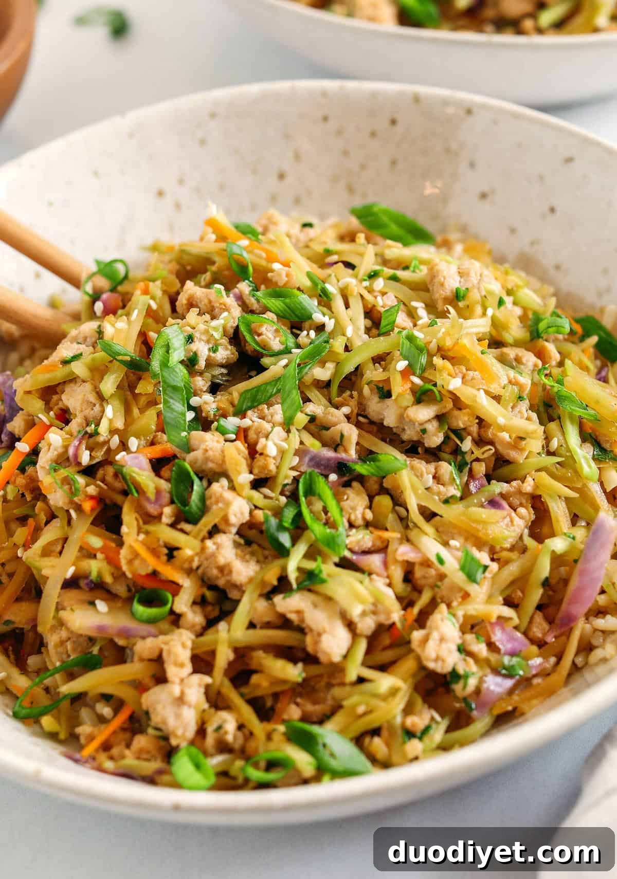Close-up of Chicken Egg Roll in a Bowl, full of colorful vegetables and seasoned ground chicken.