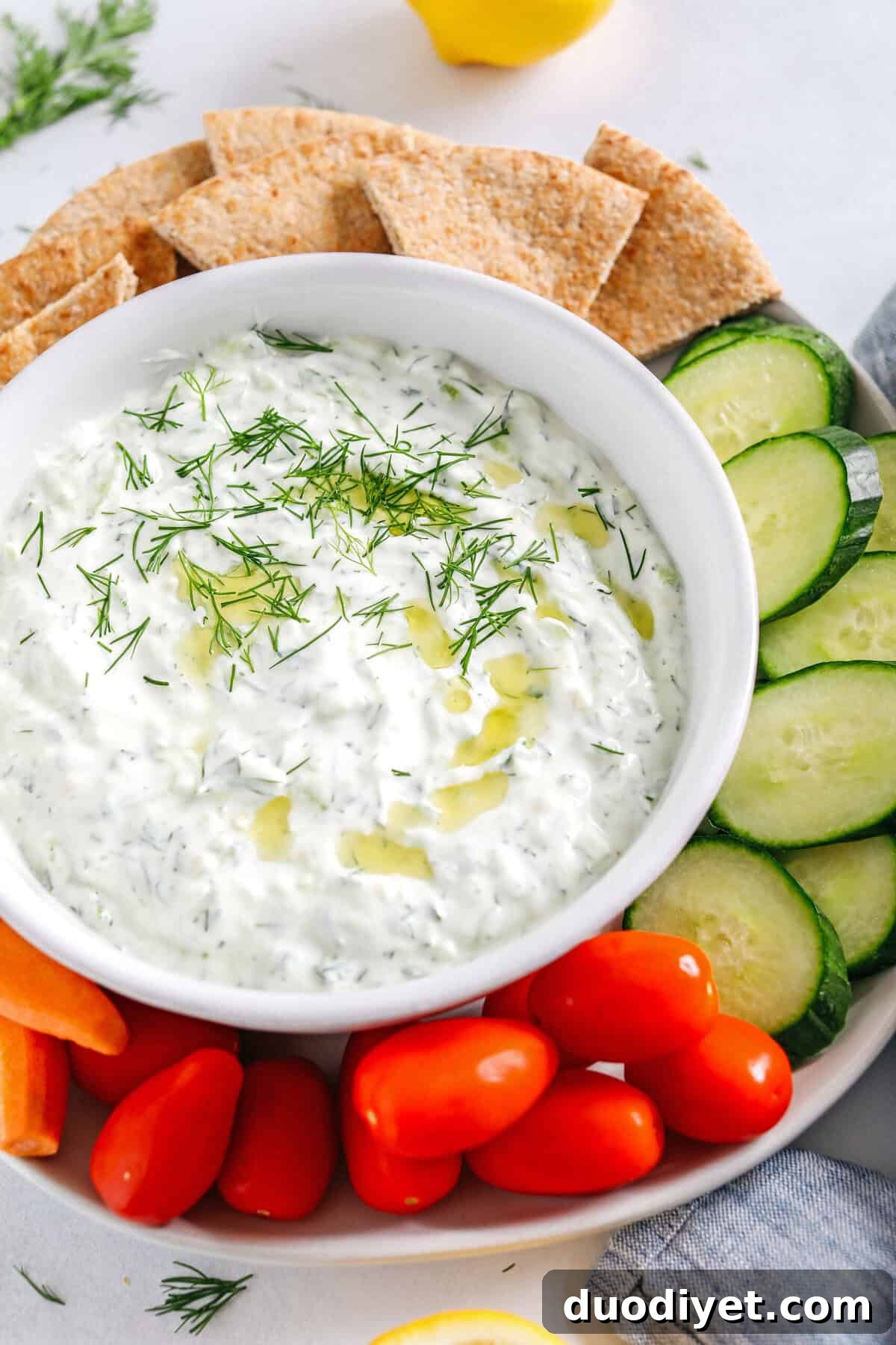 Fresh and flavorful Homemade Tzatziki Sauce is a creamy yogurt-based sauce perfect for the summer served with kabobs, grilled veggies, pita bread and more!  This recipe is easily made in just 5 minutes with a few simple ingredients!