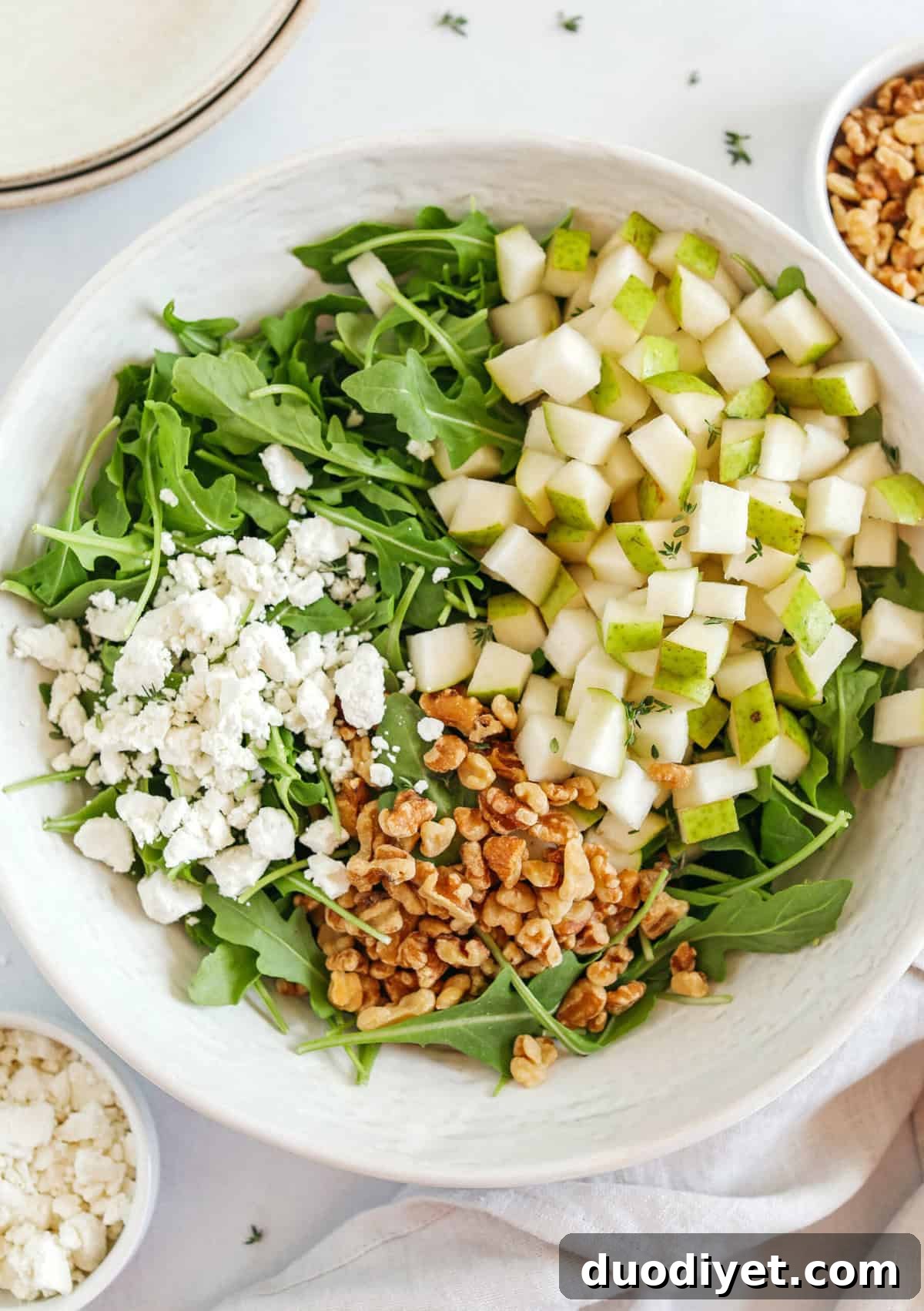 Close-up of pear and arugula salad with goat cheese and walnuts