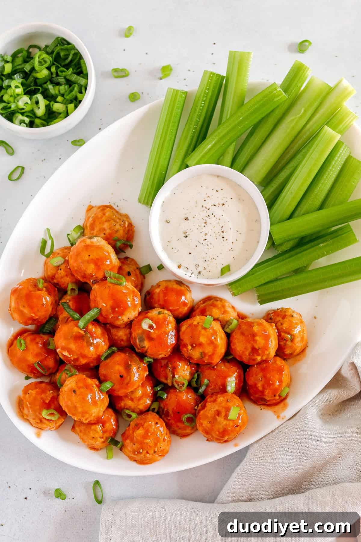 Buffalo chicken meatballs plated with rice and vegetables