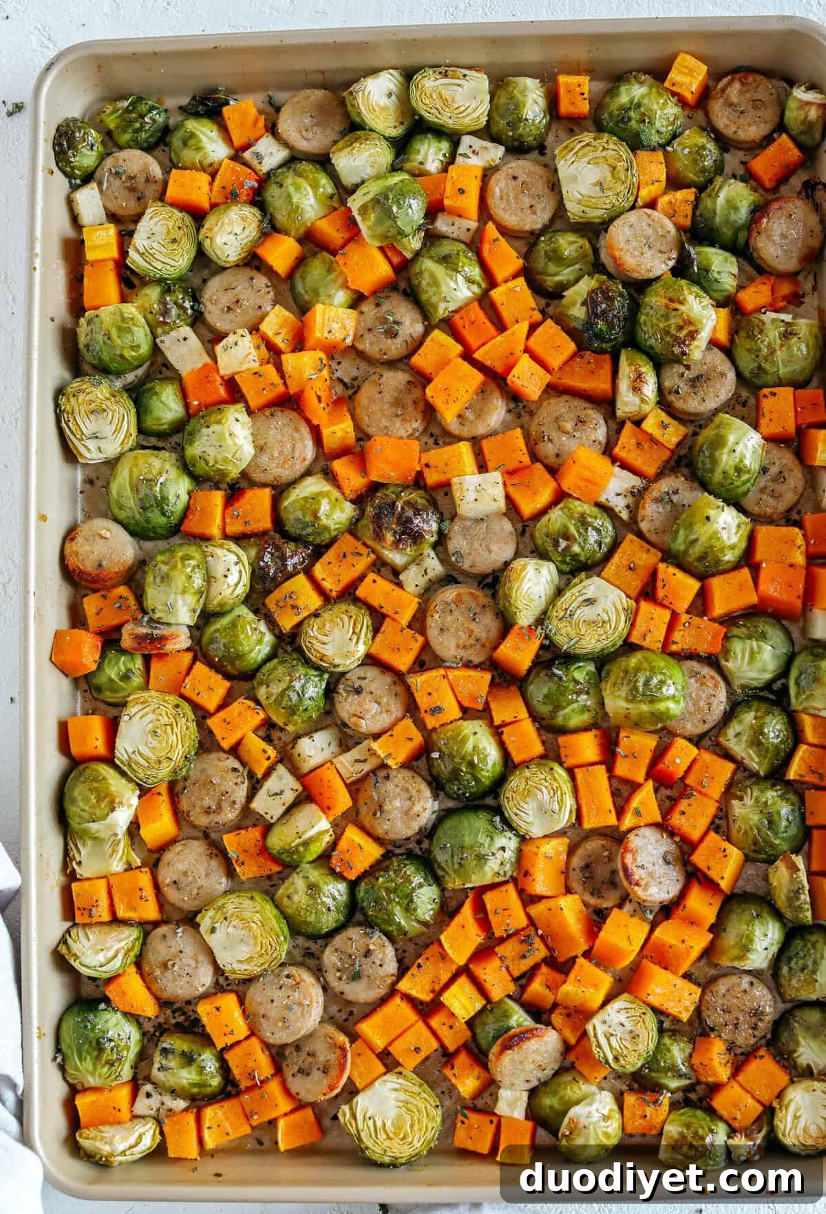 Harvest Sheet Pan Sausage and Veggies loaded with flavorful chicken sausage, butternut squash, brussels sprouts, and apples for a quick and easy dinner made in just 30 minutes! Roasted in a maple mustard glaze and fresh herbs for the perfect fall meal!