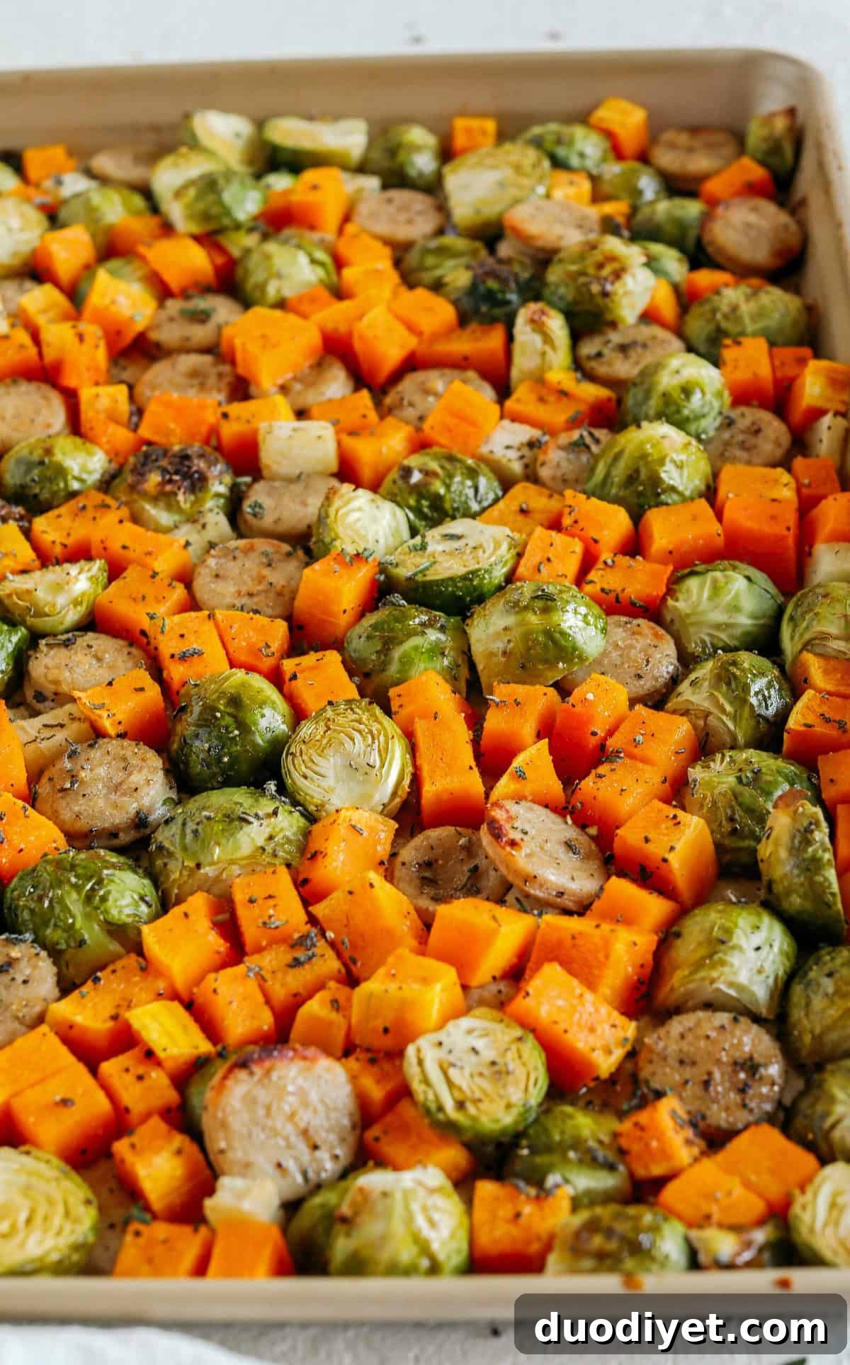 Harvest Sheet Pan Sausage and Veggies loaded with flavorful chicken sausage, butternut squash, brussels sprouts, and apples for a quick and easy dinner made in just 30 minutes! Roasted in a maple mustard glaze and fresh herbs for the perfect fall meal!