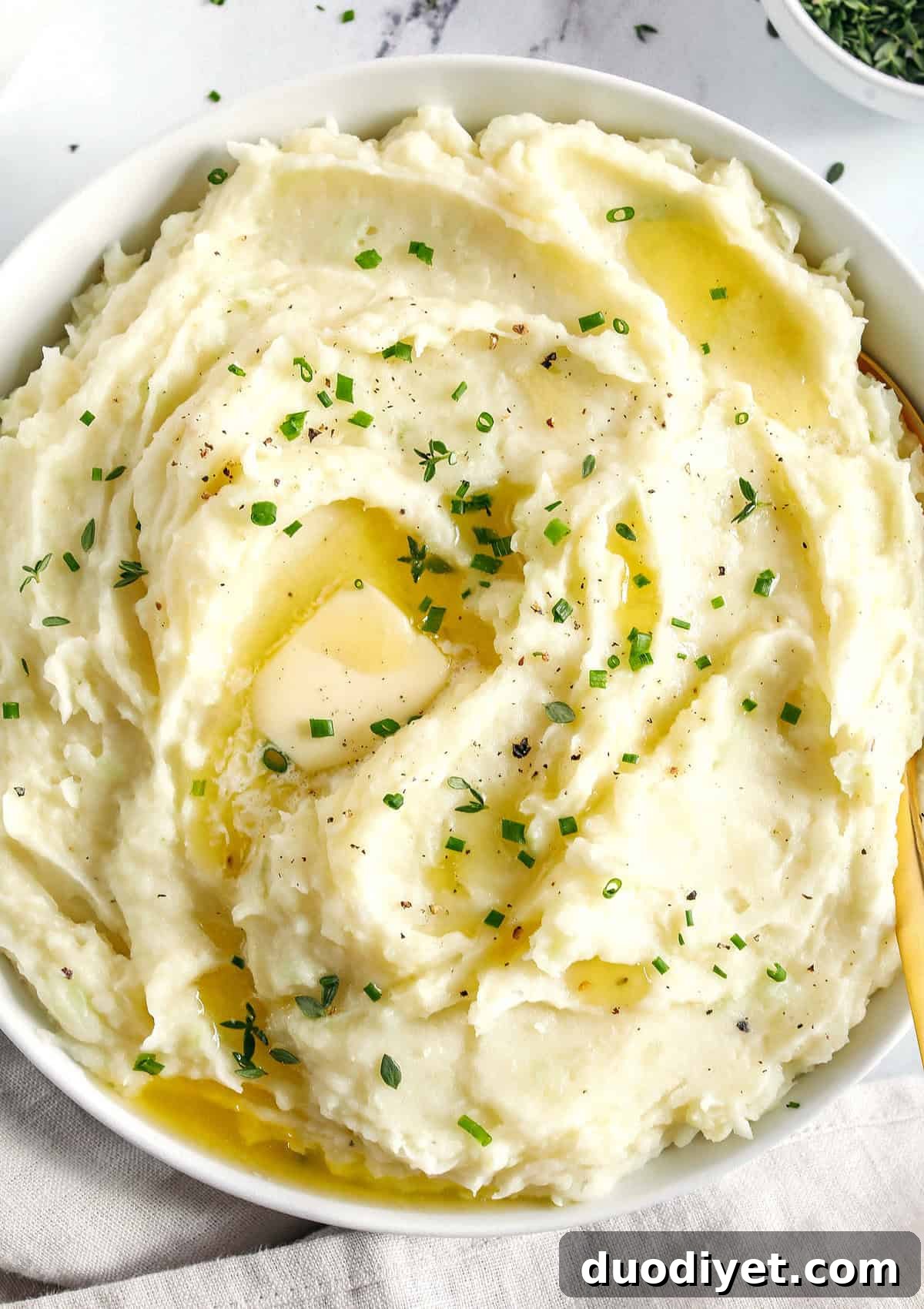 These Healthy Mashed Potatoes are creamy, absolutely delicious and made lighter with Greek yogurt, almond milk and a whole head of cauliflower!  The perfect side dish for your holiday table or weeknight dinner.
