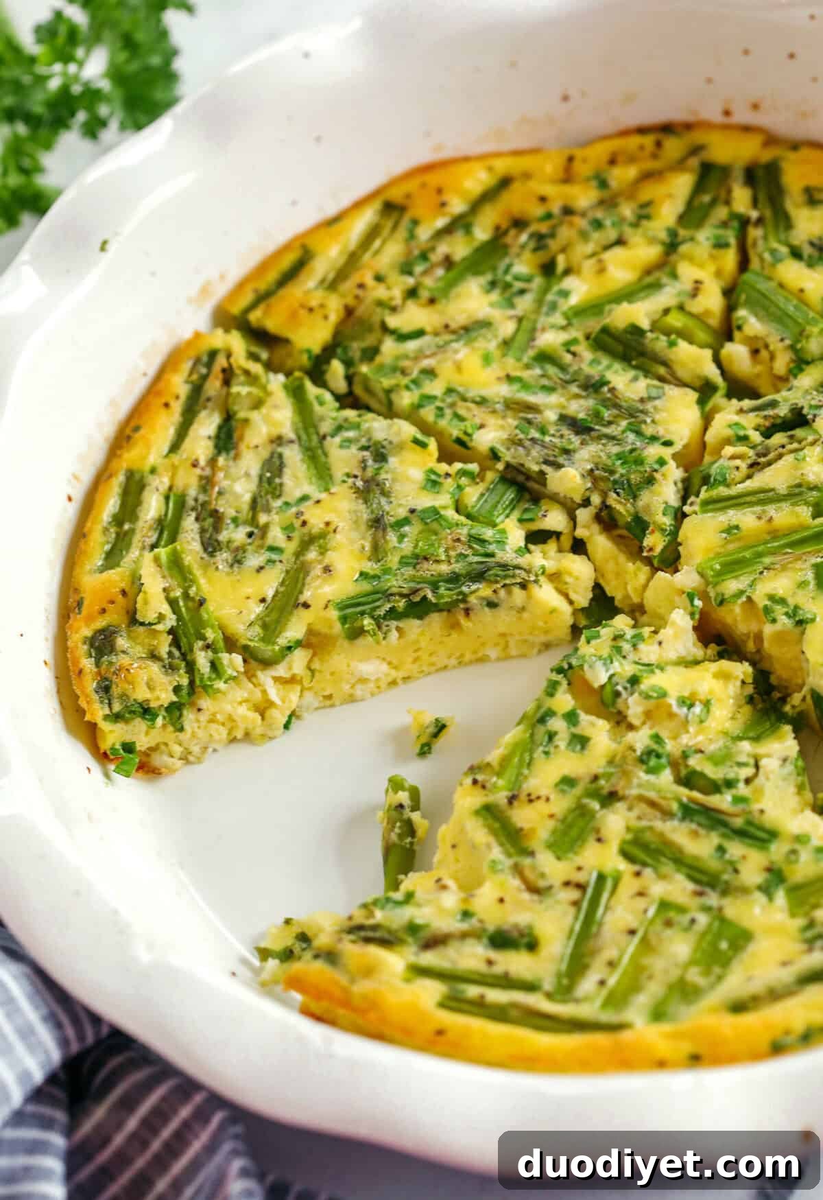Slice of asparagus feta quiche on fork