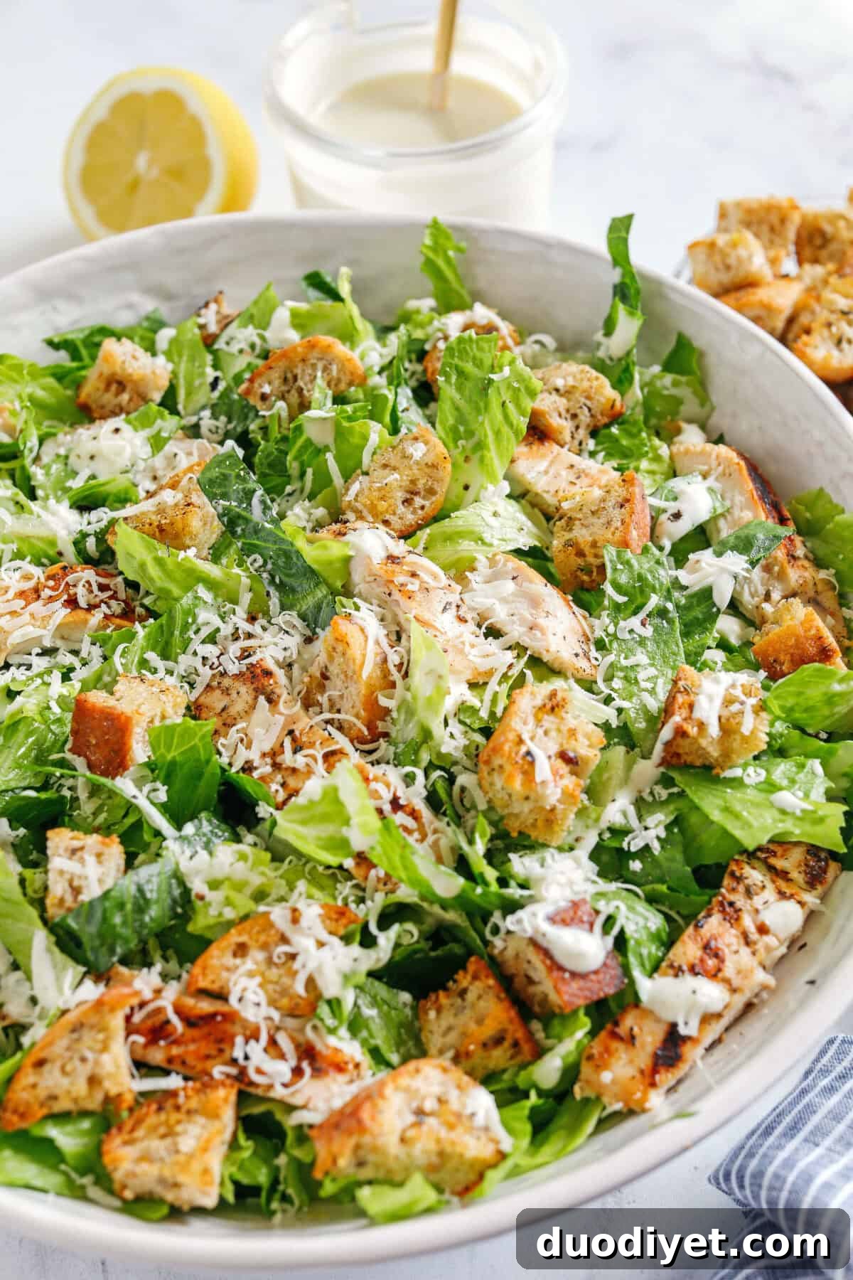 The BEST Healthy Chicken Caesar Salad made with grilled lemon chicken, garlicky homemade croutons, fresh parmesan cheese and tossed with a lightened up Greek yogurt dressing!