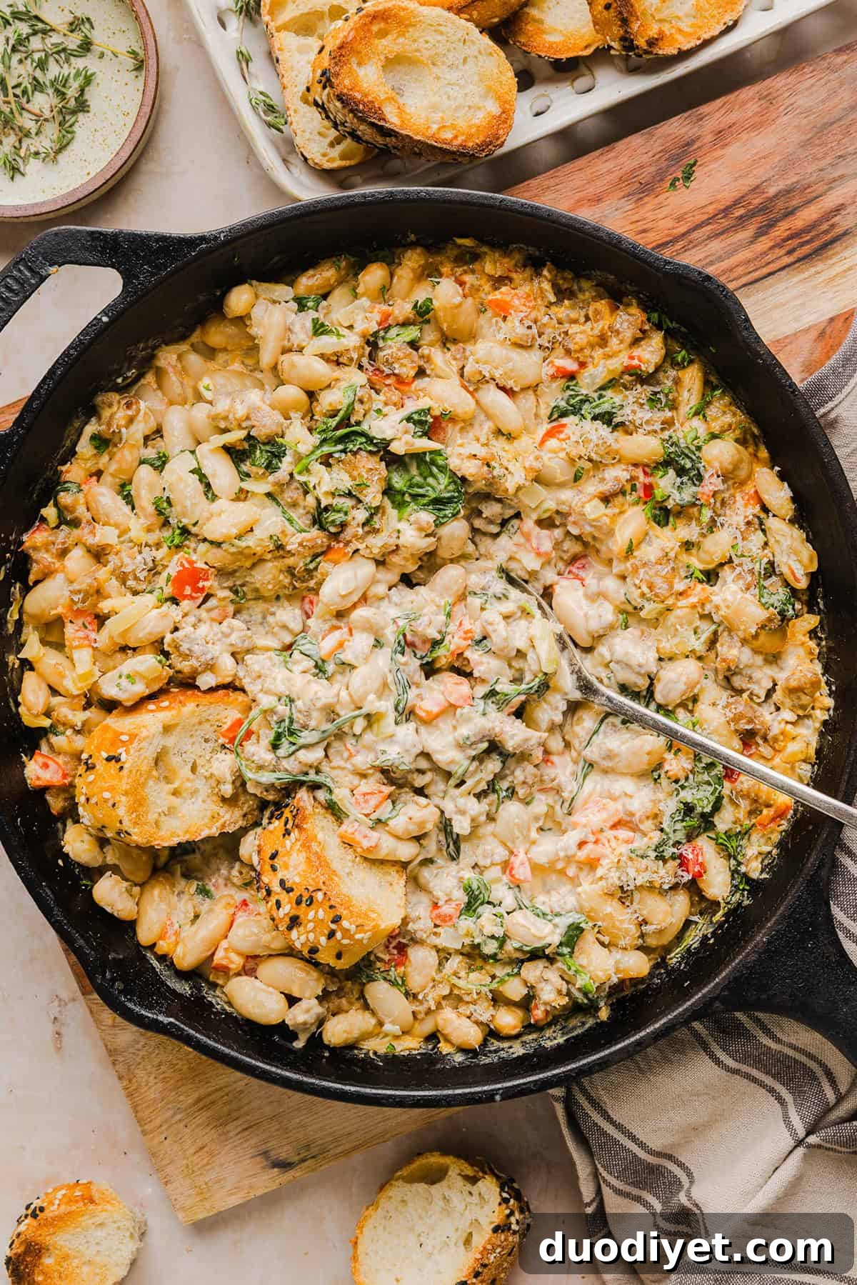 Creamy Cheesy Sausage and Bean Dip Recipe 7 This Cheesy Sausage Bean Dip is the ultimate party appetizer! Made with flavorful spicy sausage, sautéed onions, bell peppers, garlic and spinach, along with cream cheese and white beans. Topped with freshly grated parmesan cheese and served with toasted bread or Frito corn chips!