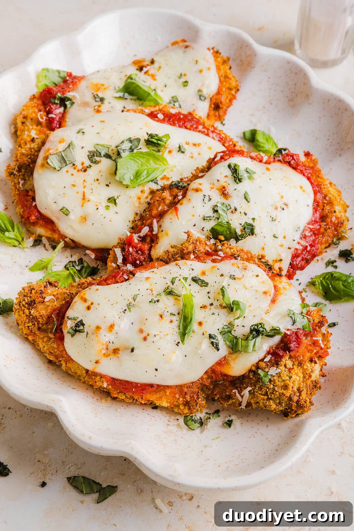 Easy Baked Chicken Parmesan made with tender juicy chicken, rich marinara sauce and melty cheese with a crisp coating that tastes delicious! This chicken is baked, not fried, and easily comes together in under 30 minutes! 