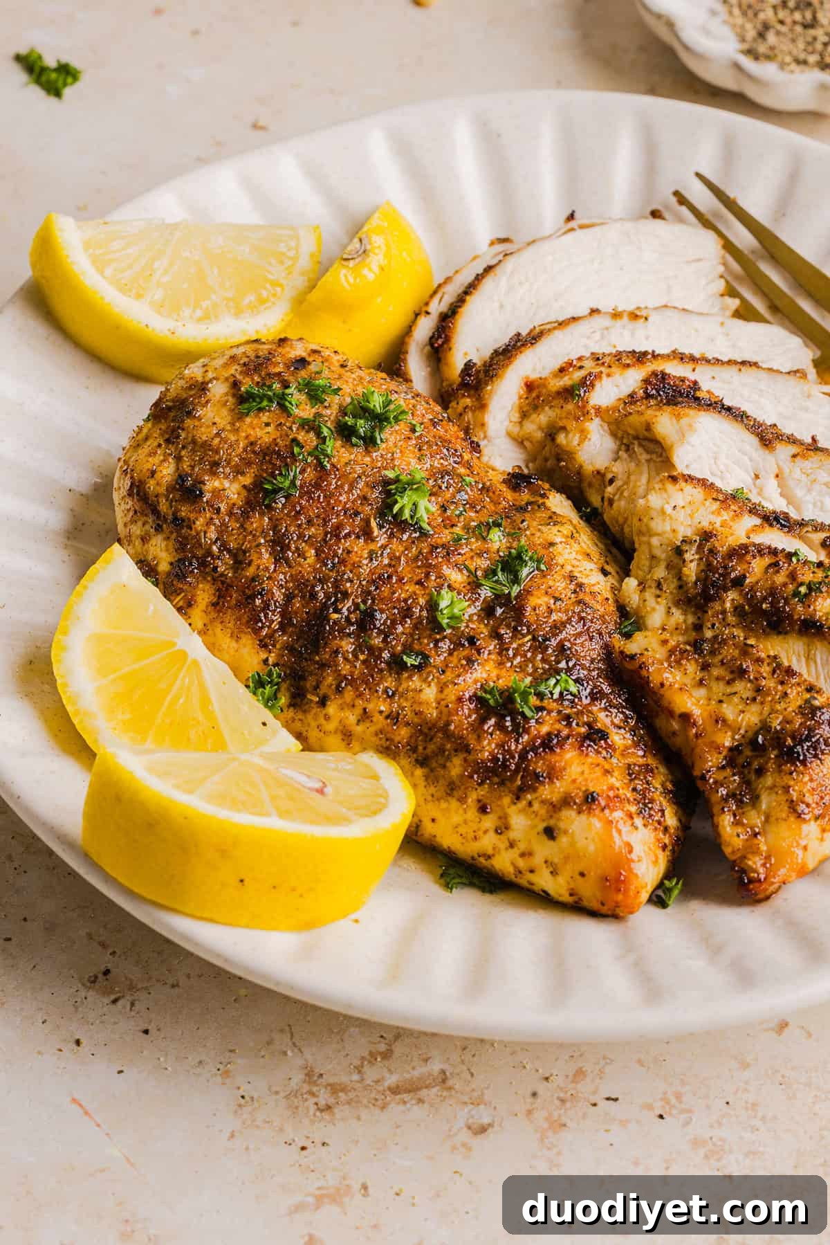 Sliced air fryer chicken served on a plate.