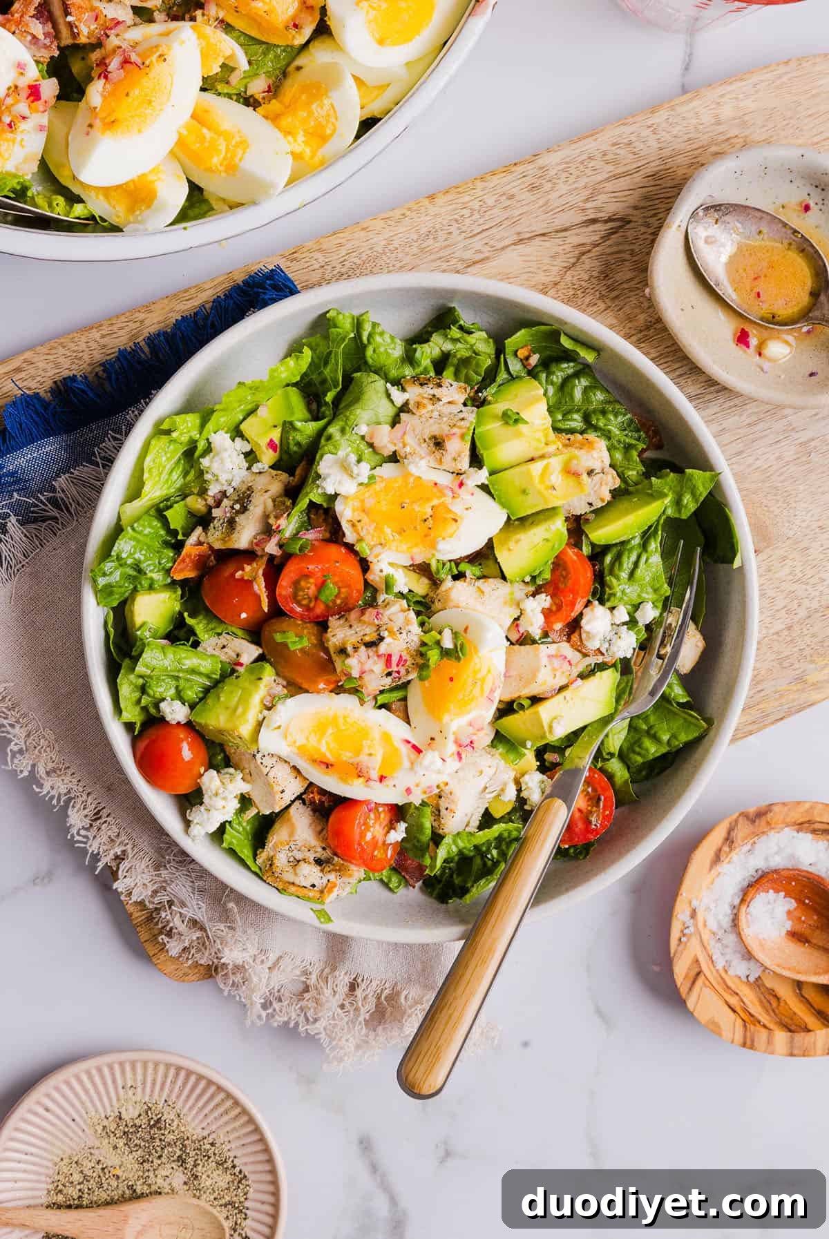 Top view of mixed Cobb salad ingredients arranged on romaine