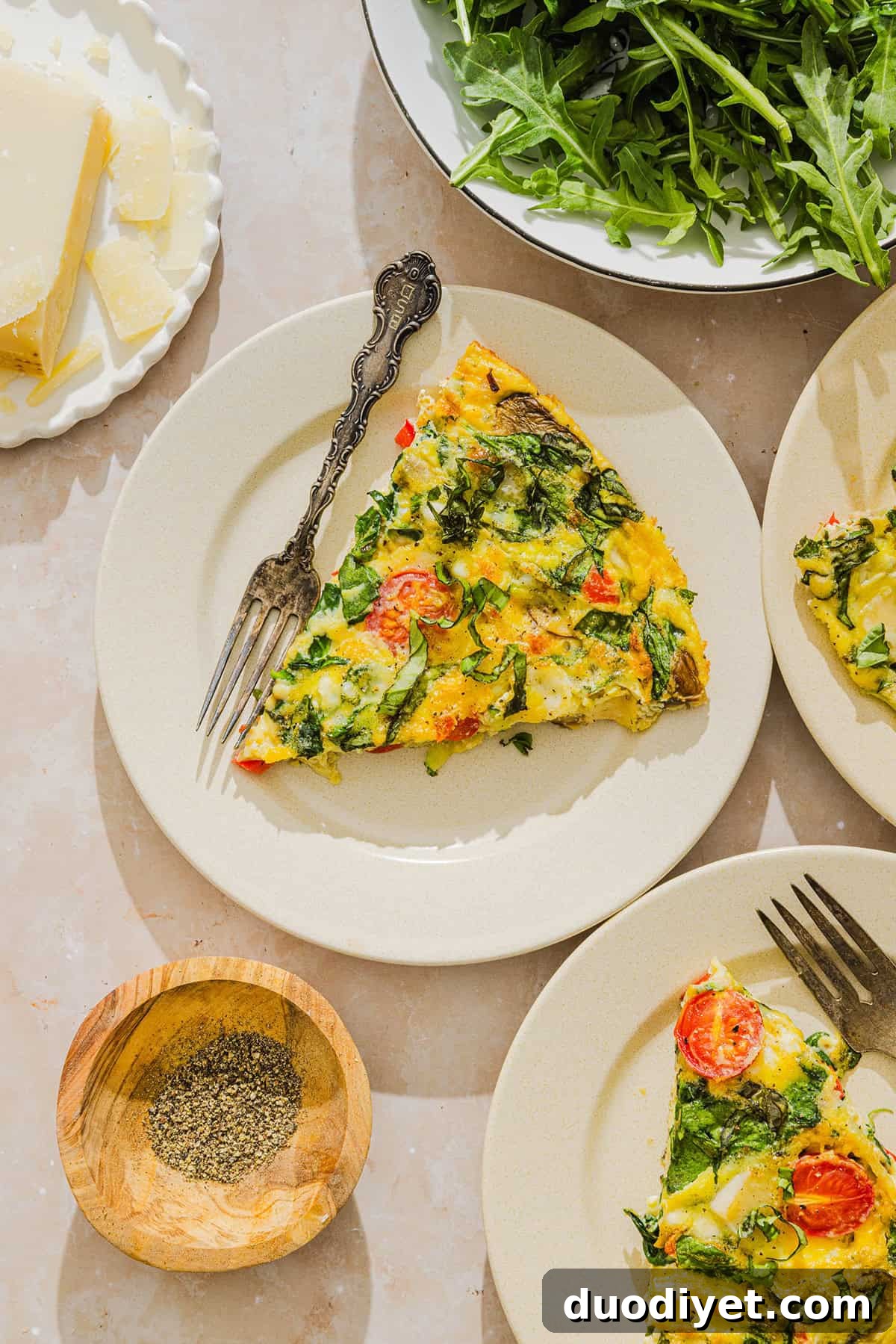 Baked Vegetable Frittata with Cottage Cheese 7 Frittata slices plated with fresh basil garnish.