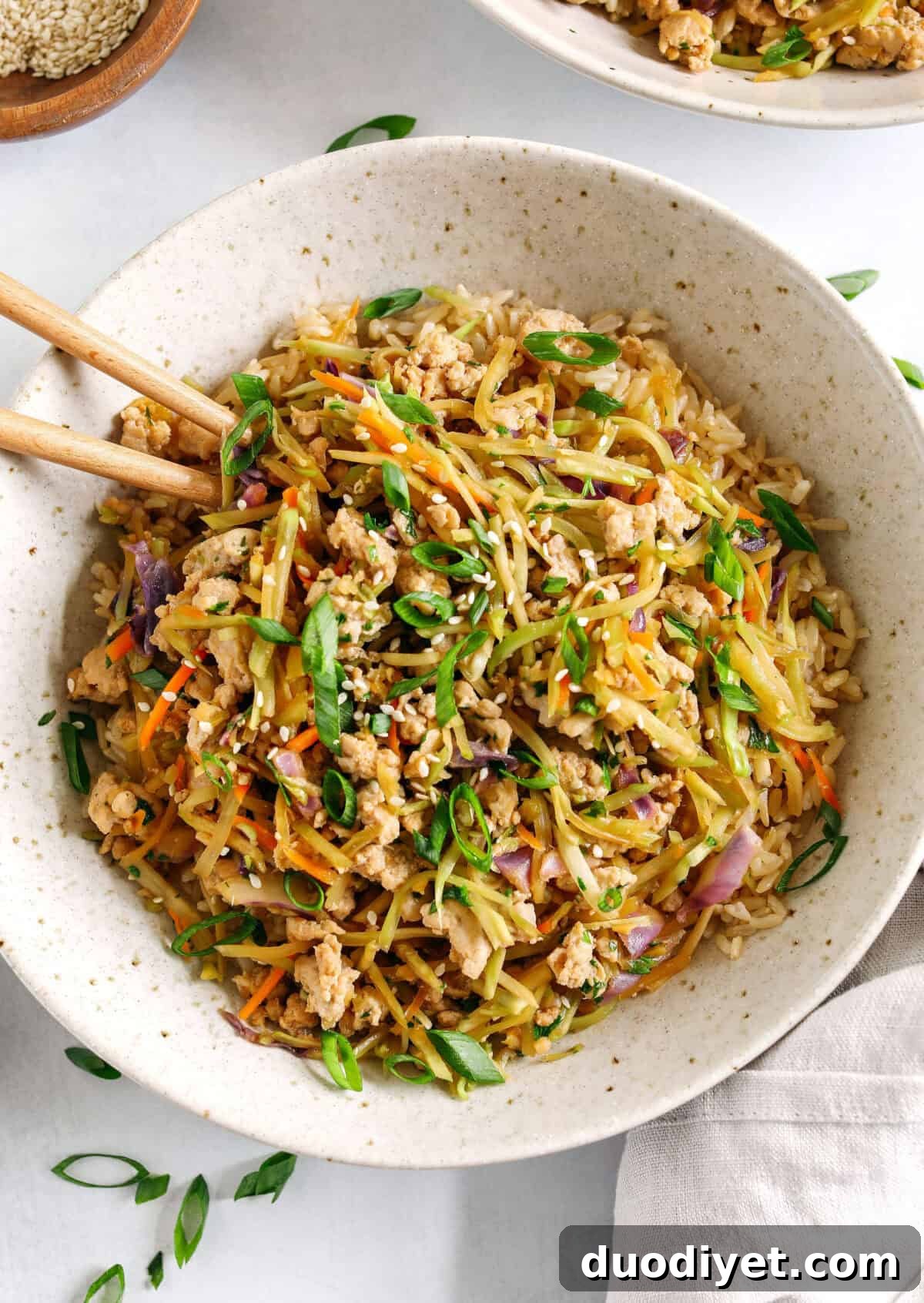 Easy and flavorful Chicken Egg Roll in a Bowl that comes together in under 20 minutes packed with so much flavor! Perfect healthy weeknight dinner served over rice and garnished with green onions and sesame seeds.