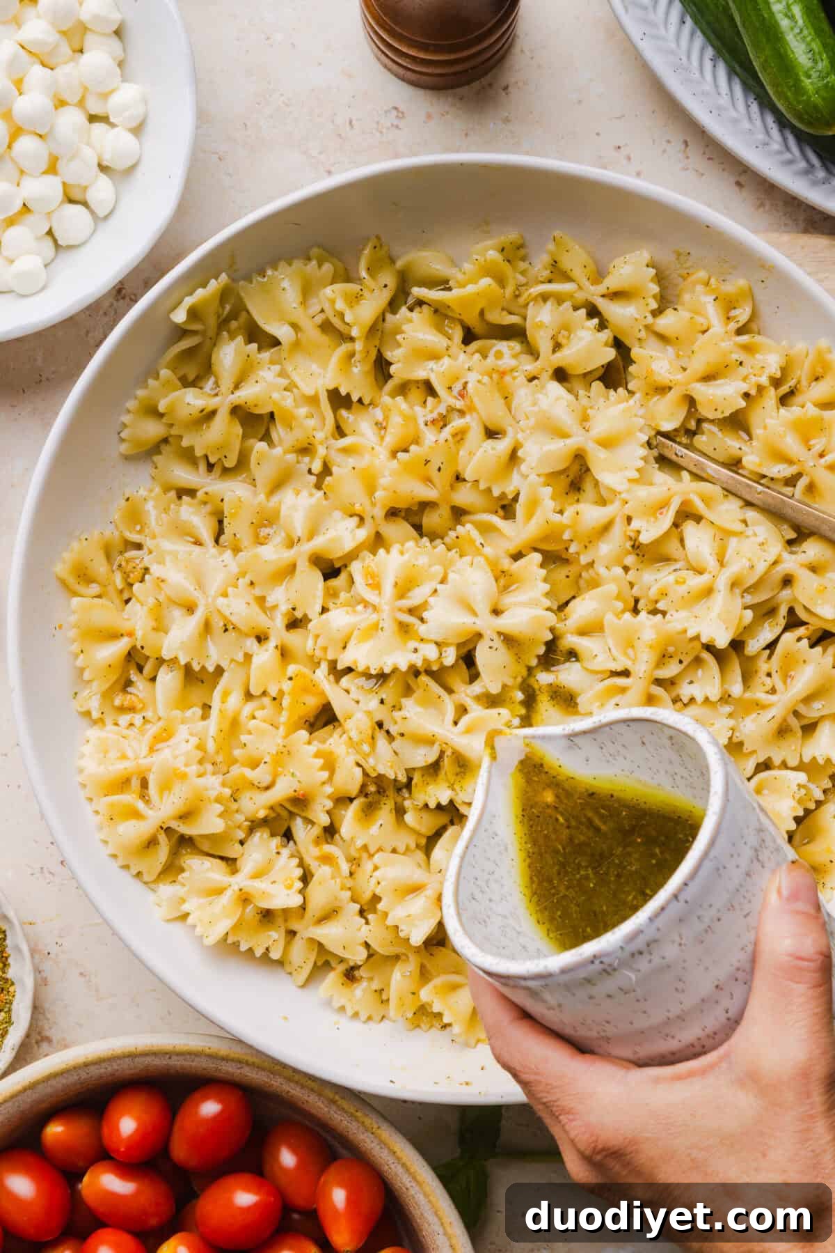 Serving bowl of Caprese Pasta Salad garnished with basil
