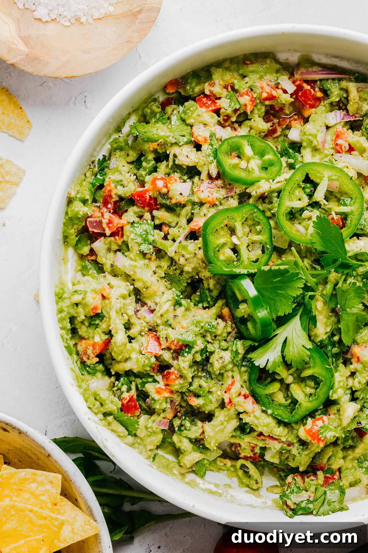 Chunky Guacamole Recipe with Tomato and Onion 6 Serving guacamole with chips.