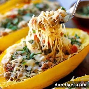 Plated spaghetti squash boat with spicy sausage and fresh basil
