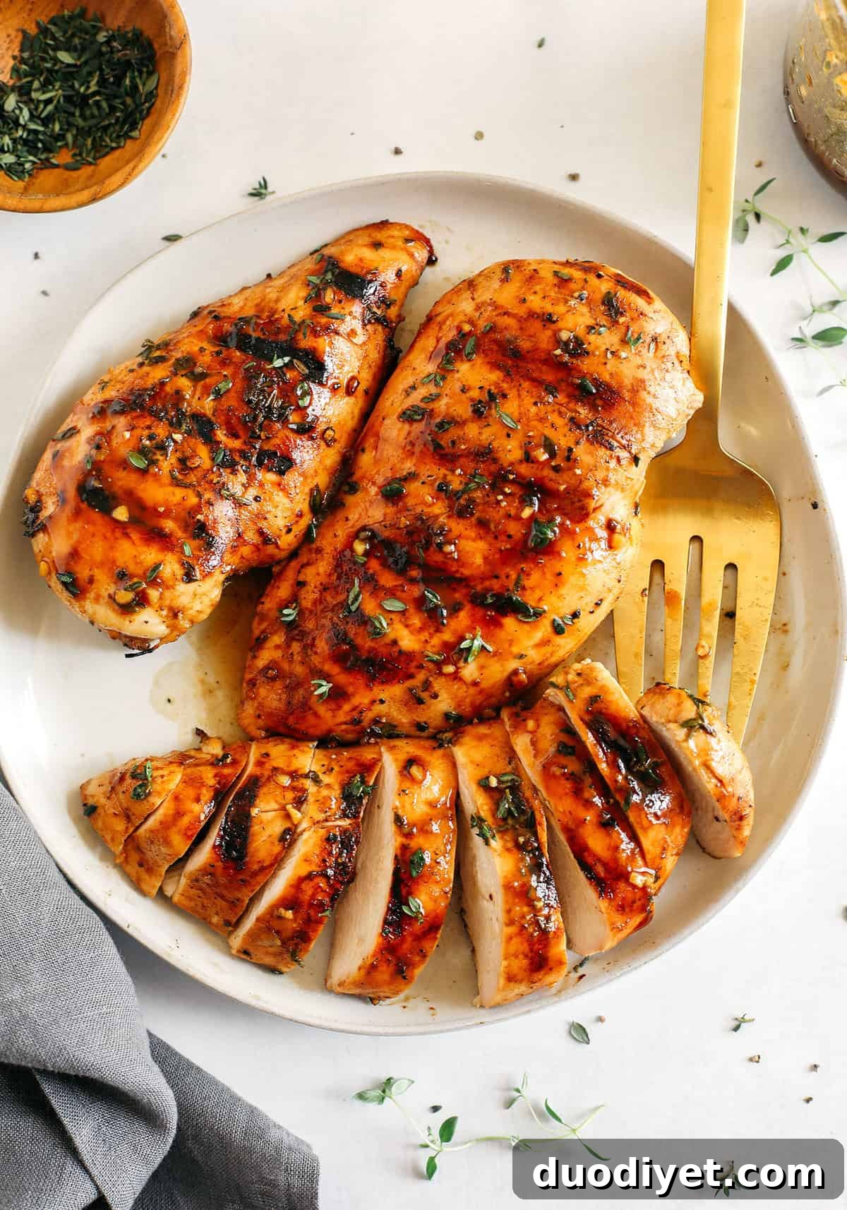 Moist and juicy chicken breasts marinated in a rich maple balsamic herb glaze, seasoned with fresh herbs, and grilled to perfection for a healthy weeknight meal!