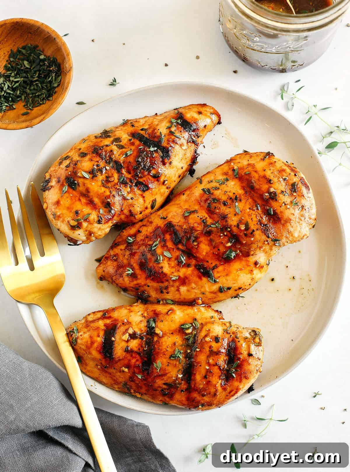 Moist and juicy chicken breasts marinated in a rich maple balsamic herb glaze, seasoned with fresh herbs, and grilled to perfection for a healthy weeknight meal!
