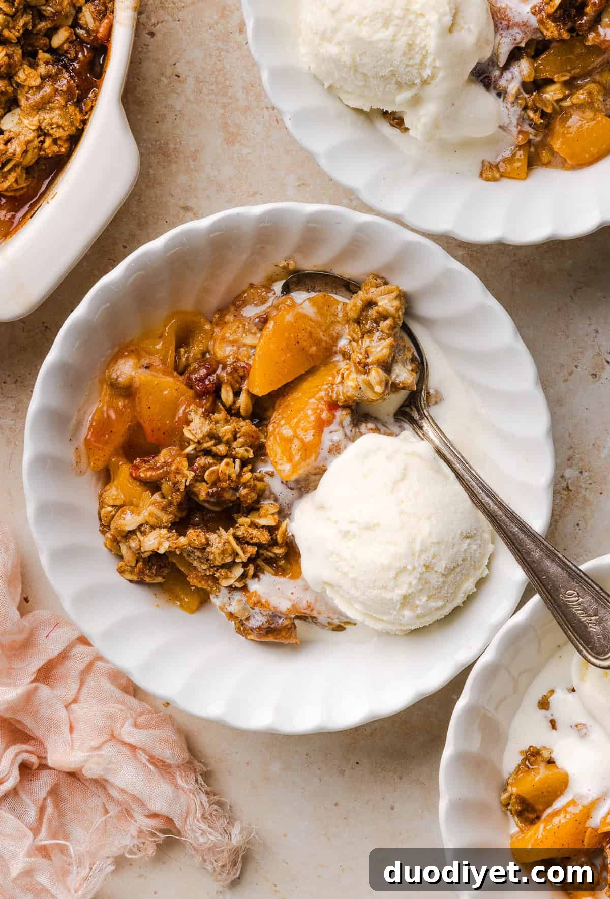 This Healthy Peach Crisp recipe is made with juicy fresh peaches and a wholesome oat pecan crumble naturally sweetened with maple syrup. An easy summer dessert that is warm, cozy, and perfect with vanilla ice cream!