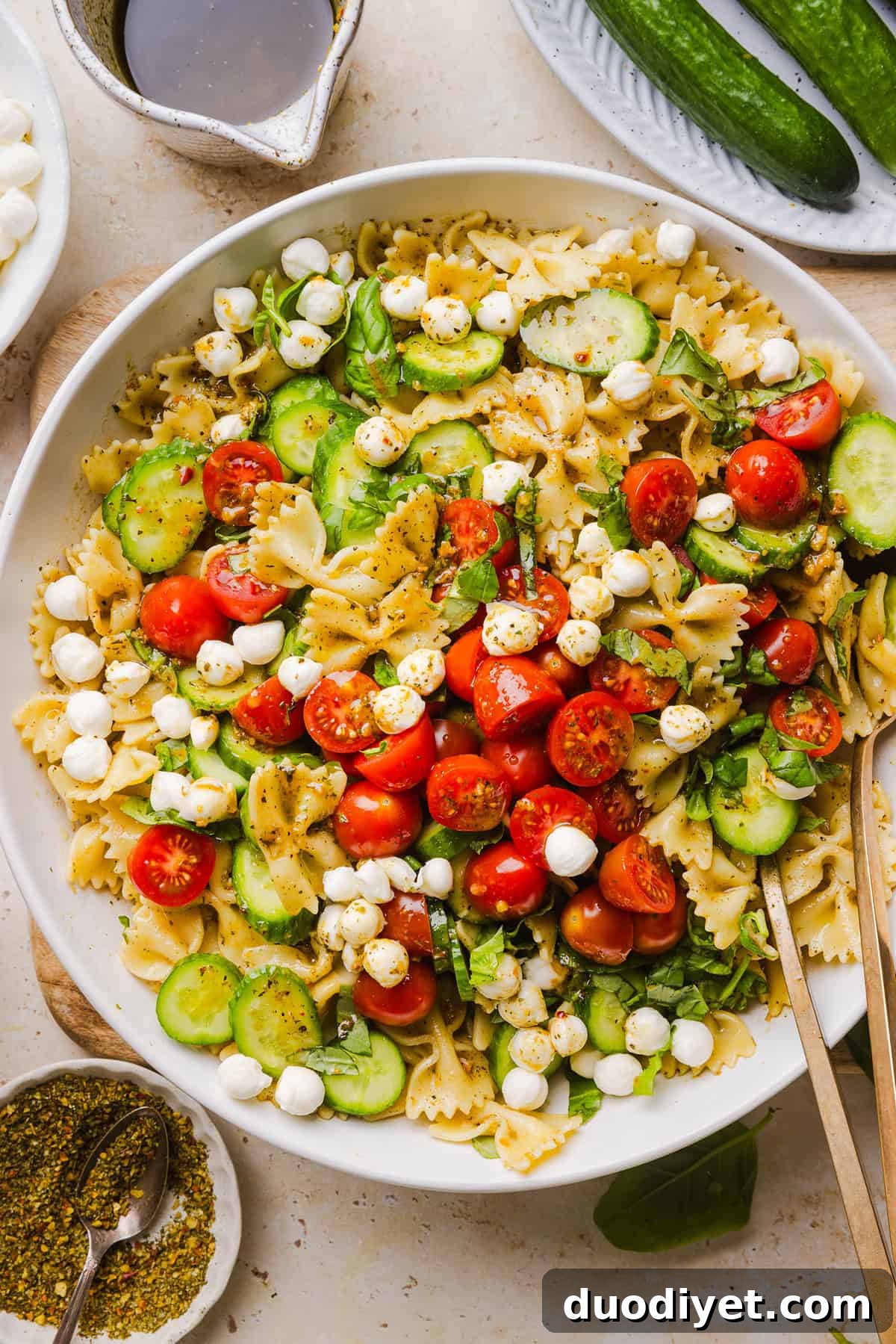 This Easy Caprese Pasta Salad is loaded with fresh tomatoes, mozzarella pearls, fresh basil, cucumbers, and a delicious homemade herb vinaigrette. The perfect make-ahead summer side dish for BBQs, lunches and meal prep!
