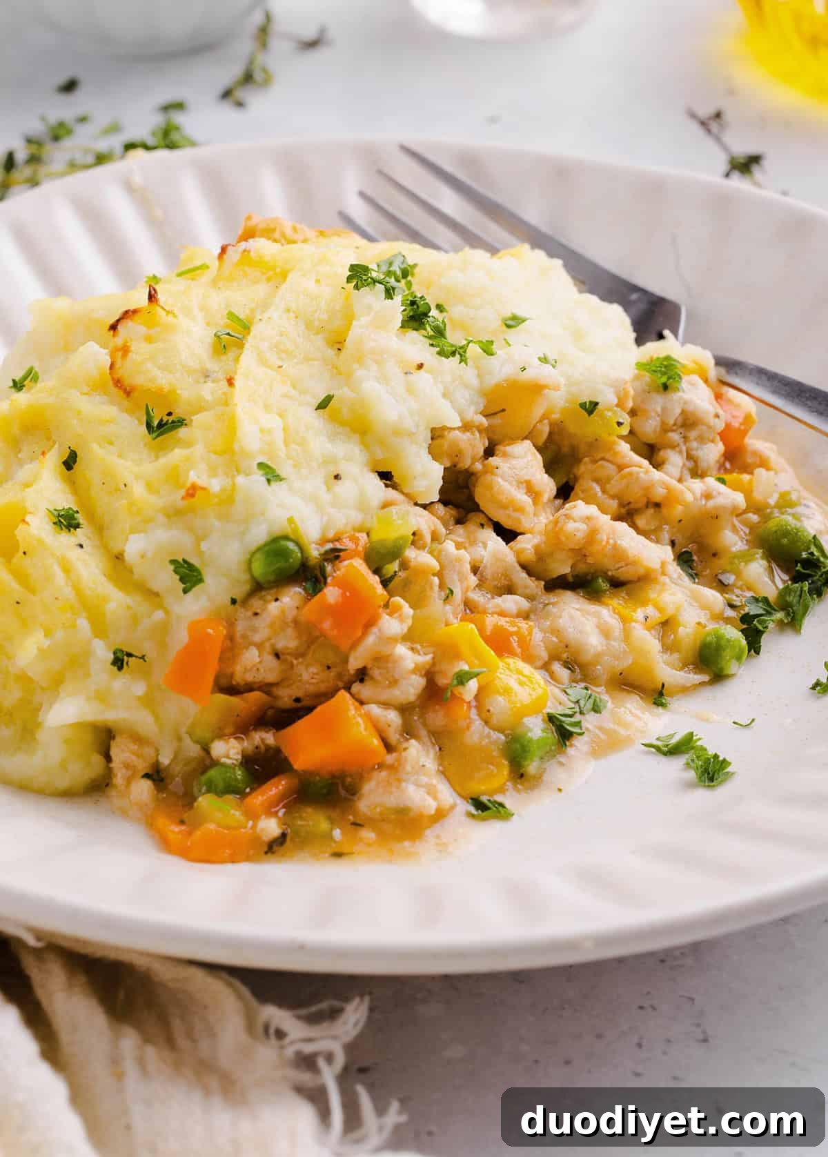 Cozy and delicious Healthy Turkey Shepherd's Pie Recipe made with lean ground turkey, colorful vegetables, rich homemade gravy and topped with lighter mashed potatoes. A healthier twist on a classic comfort food dish the whole family will love!
