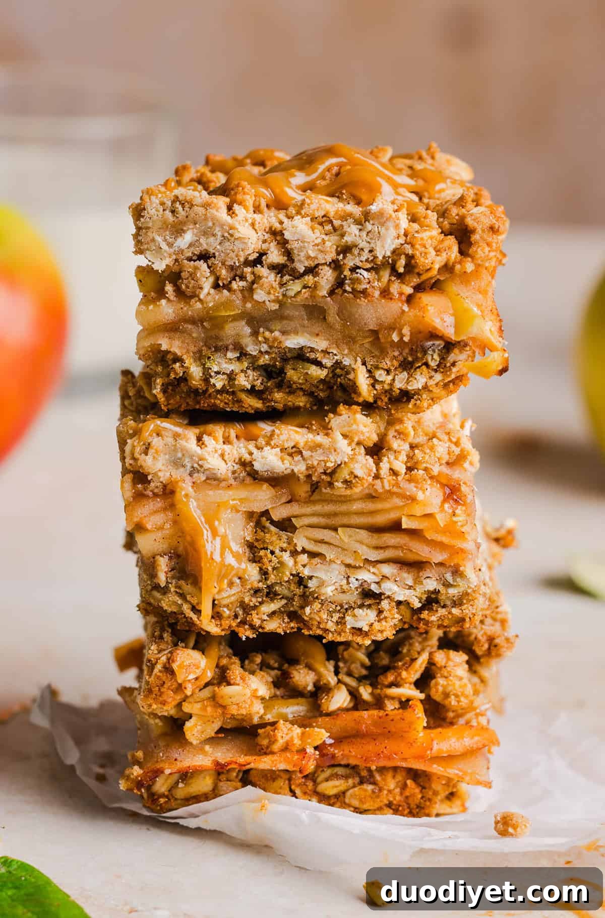 Apple pie crumble bars stacked on a plate with salted caramel drizzle